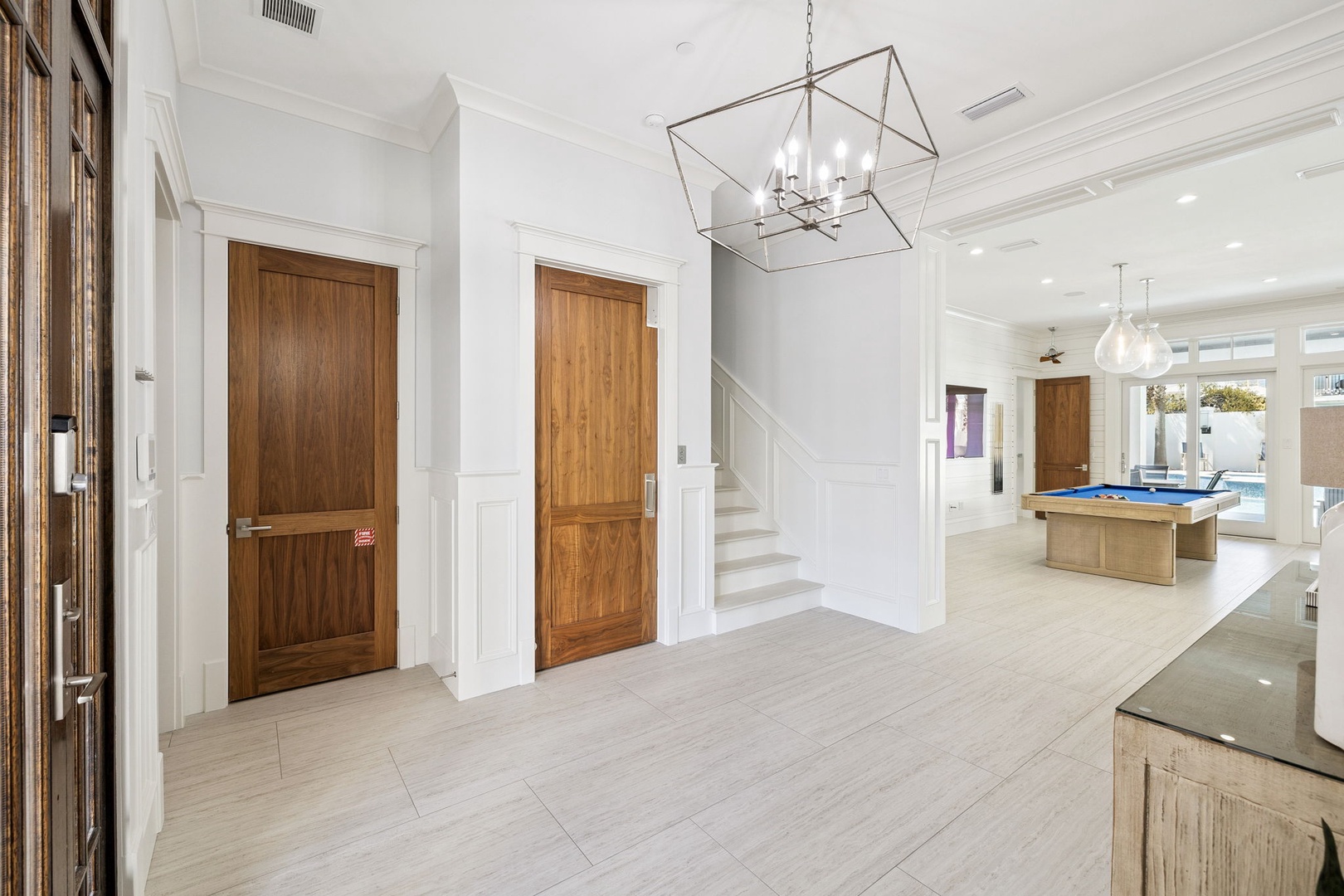 Your spacious open floor plan flows seamlessly from entrance to entertainment, featuring elegant lighting and billiards for endless fun.