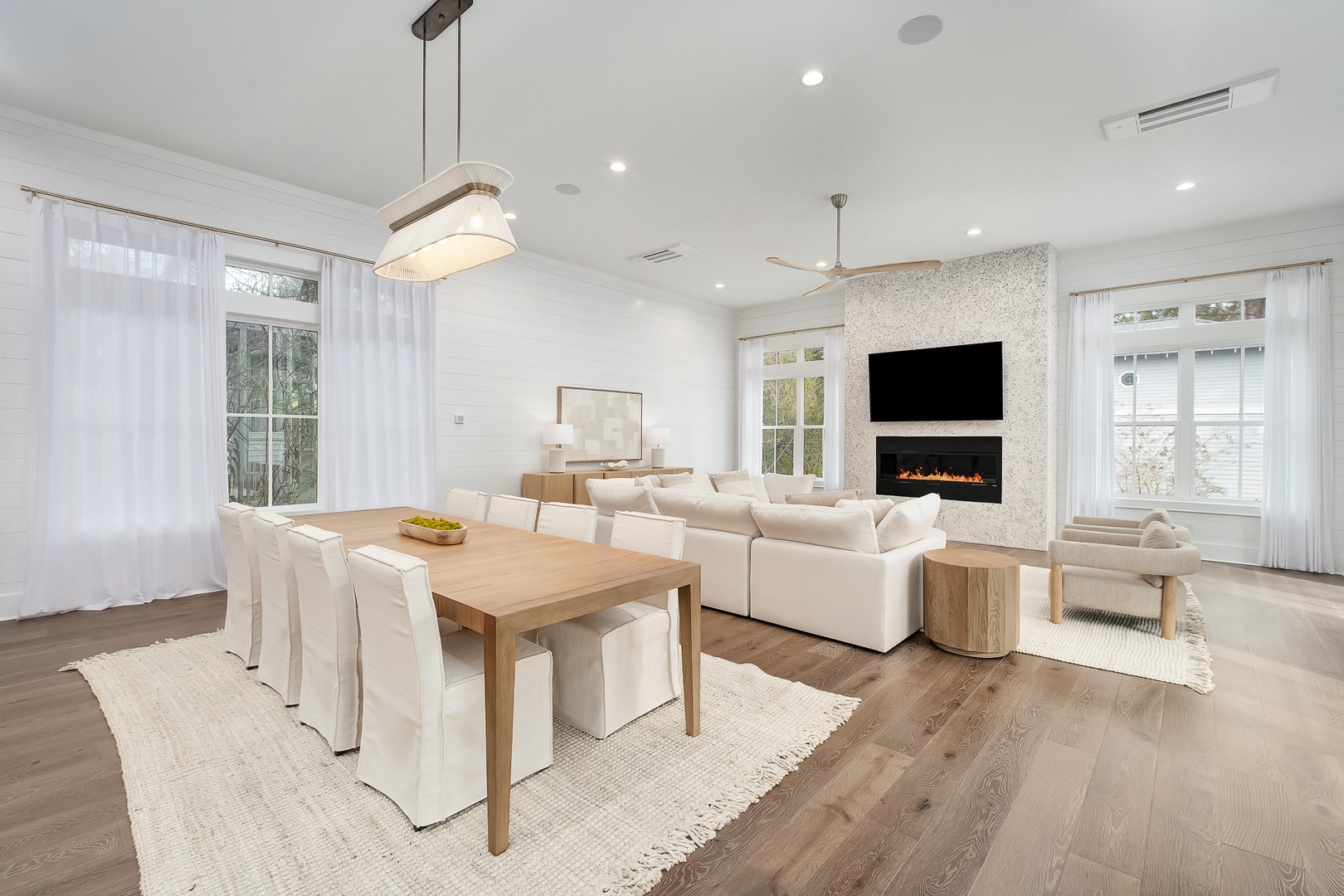 Unwind in your elegant open-plan living space featuring a cozy fireplace, smart TV, and dining for eight—perfect for memorable evenings together.