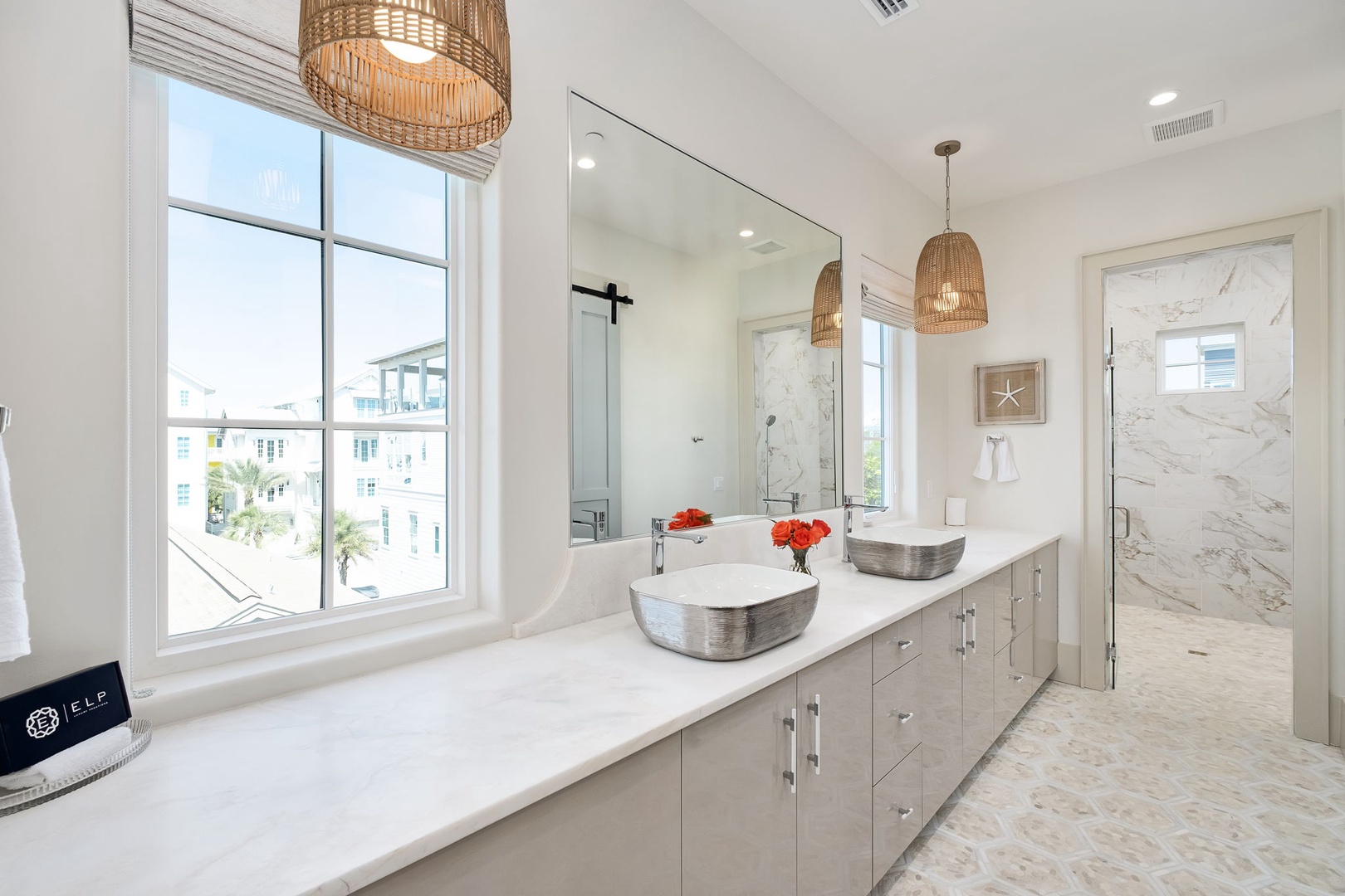 Unwind in your spa-like master bathroom with dual vanities, luxurious soaking tub, and marble walk-in shower beneath warm woven pendant lights.