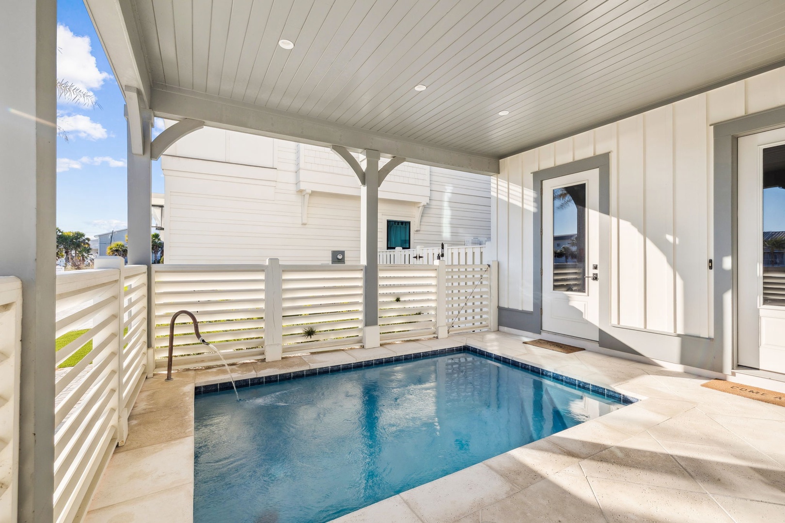 Your private pool awaits under a covered patio, perfect for cooling off after beach days in this coastal retreat.
