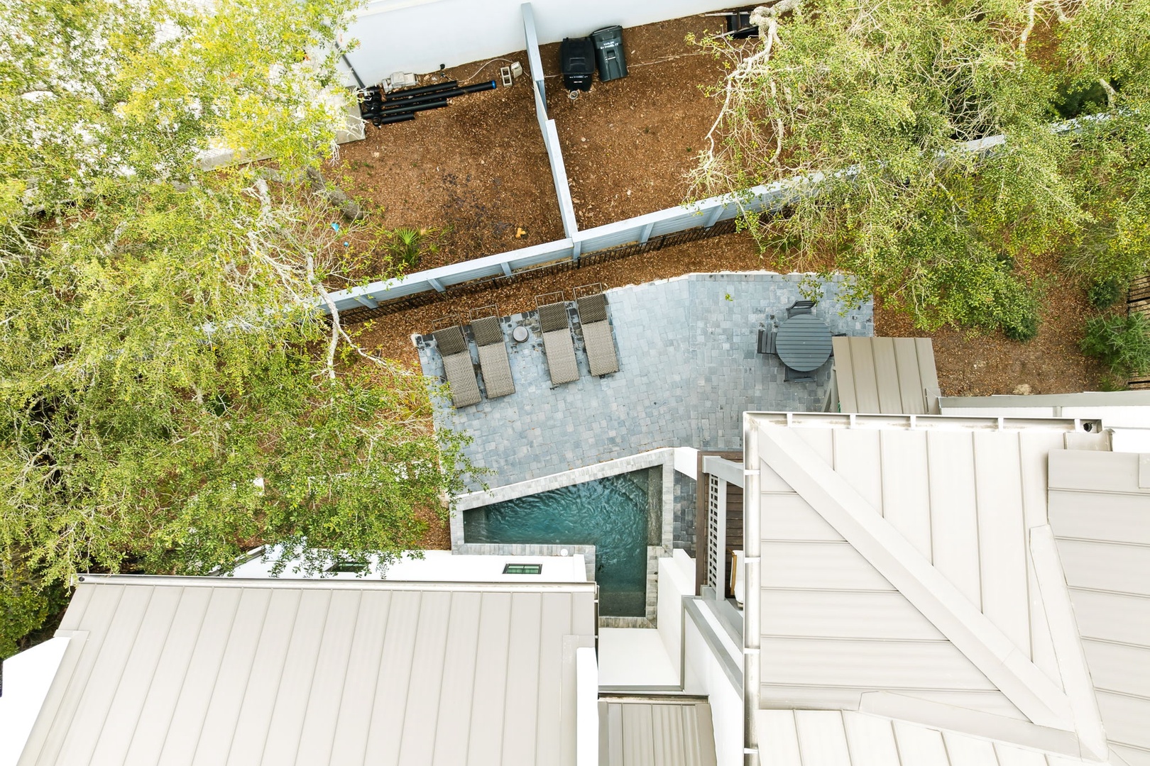 Aerial view showcases the property's private pool, patio seating area, and lush natural surroundings.