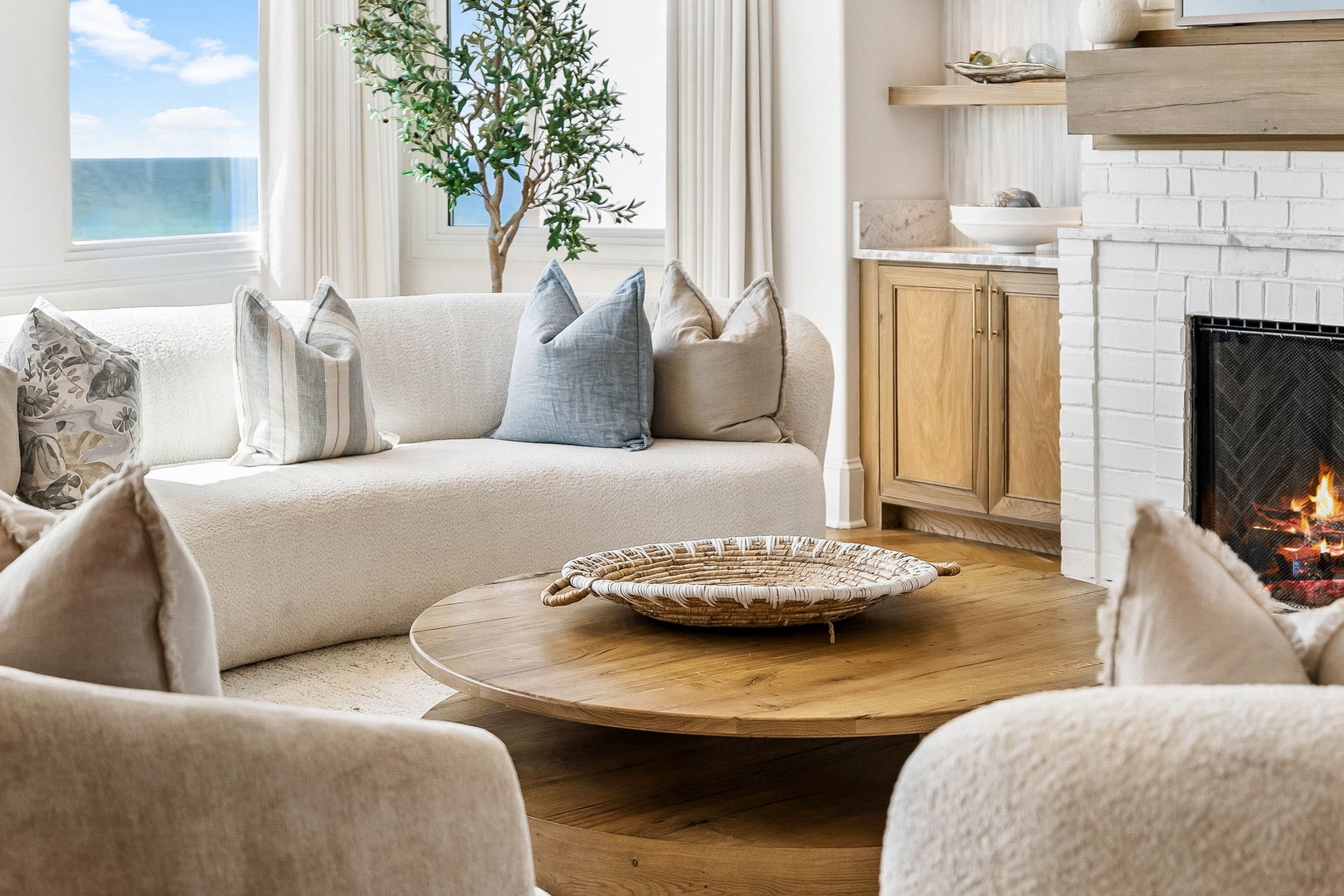 Curl up on the plush sofa with ocean breezes drifting in, fireplace crackling softly beside you. Natural light fills your peaceful retreat, perfect for unwinding after beach adventures.