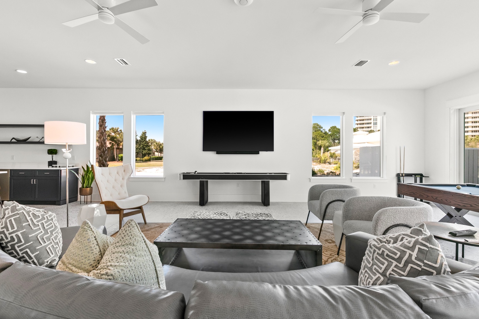 Sink into plush seating and enjoy your favorite entertainment in this airy, sunlit living space. High ceilings and windows invite natural light, while ceiling fans keep you comfortable year-round.