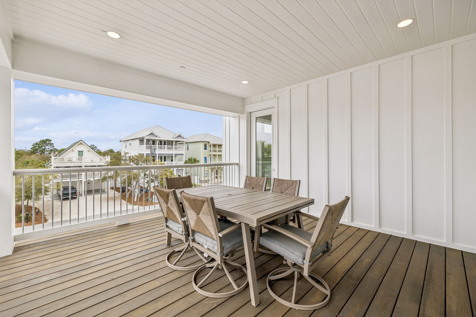 Gather around your private dining table on this spacious covered balcony, where neighborhood views and gentle breezes create the perfect setting for memorable meals together.