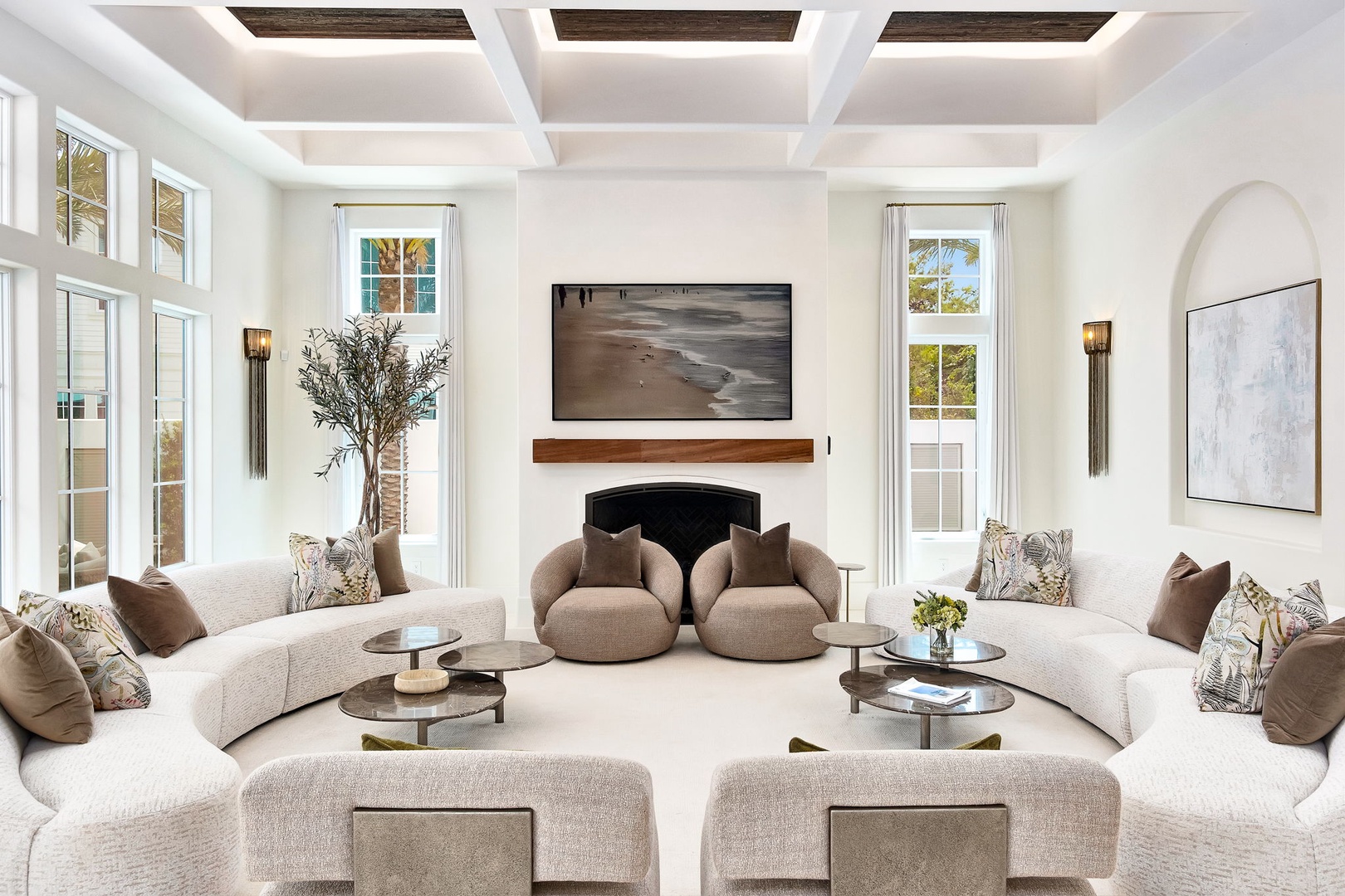 Sink into plush seating beneath coffered ceilings as natural light pours through floor-to-ceiling windows, creating a serene space where you can unwind by the fireplace.