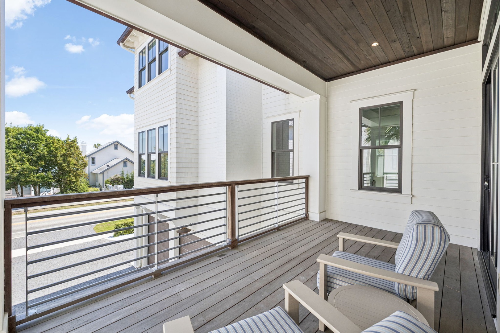 Unwind on your private balcony with comfortable seating and neighborhood views through modern railings.