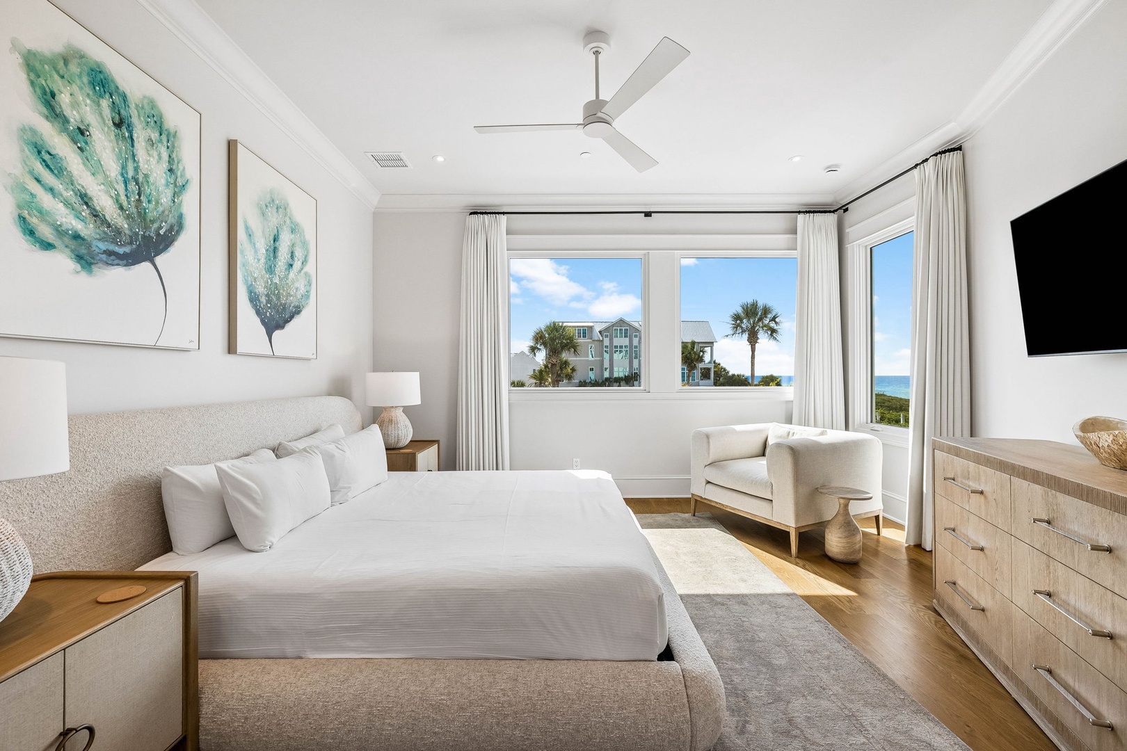 Wake up to stunning ocean views through your bedroom's picture windows. Coastal artwork and soft neutrals create a serene retreat where you can unwind in comfort.