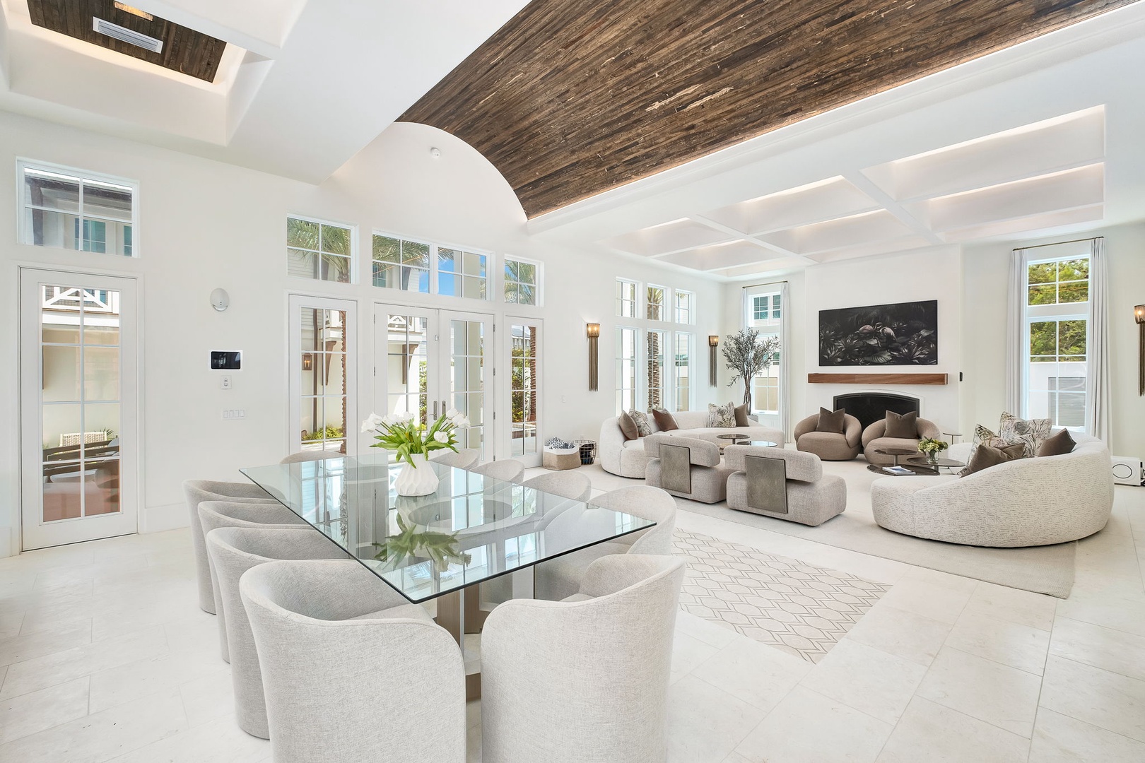 Step into your bright, open sanctuary where vaulted wood ceilings and floor-to-ceiling windows create a seamless flow between elegant indoor comfort and the lush outdoors.