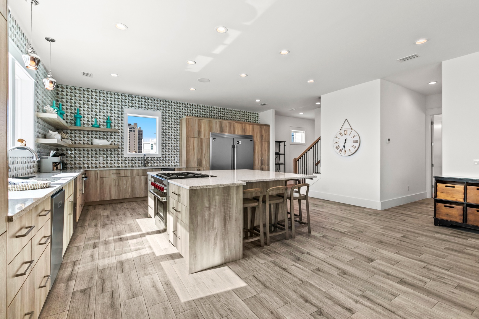 Step into your stylish open-concept space where modern design meets comfort. The bright kitchen features wood-tone cabinetry, gleaming countertops, and a central island with bar seating—perfect for cooking and gathering together.