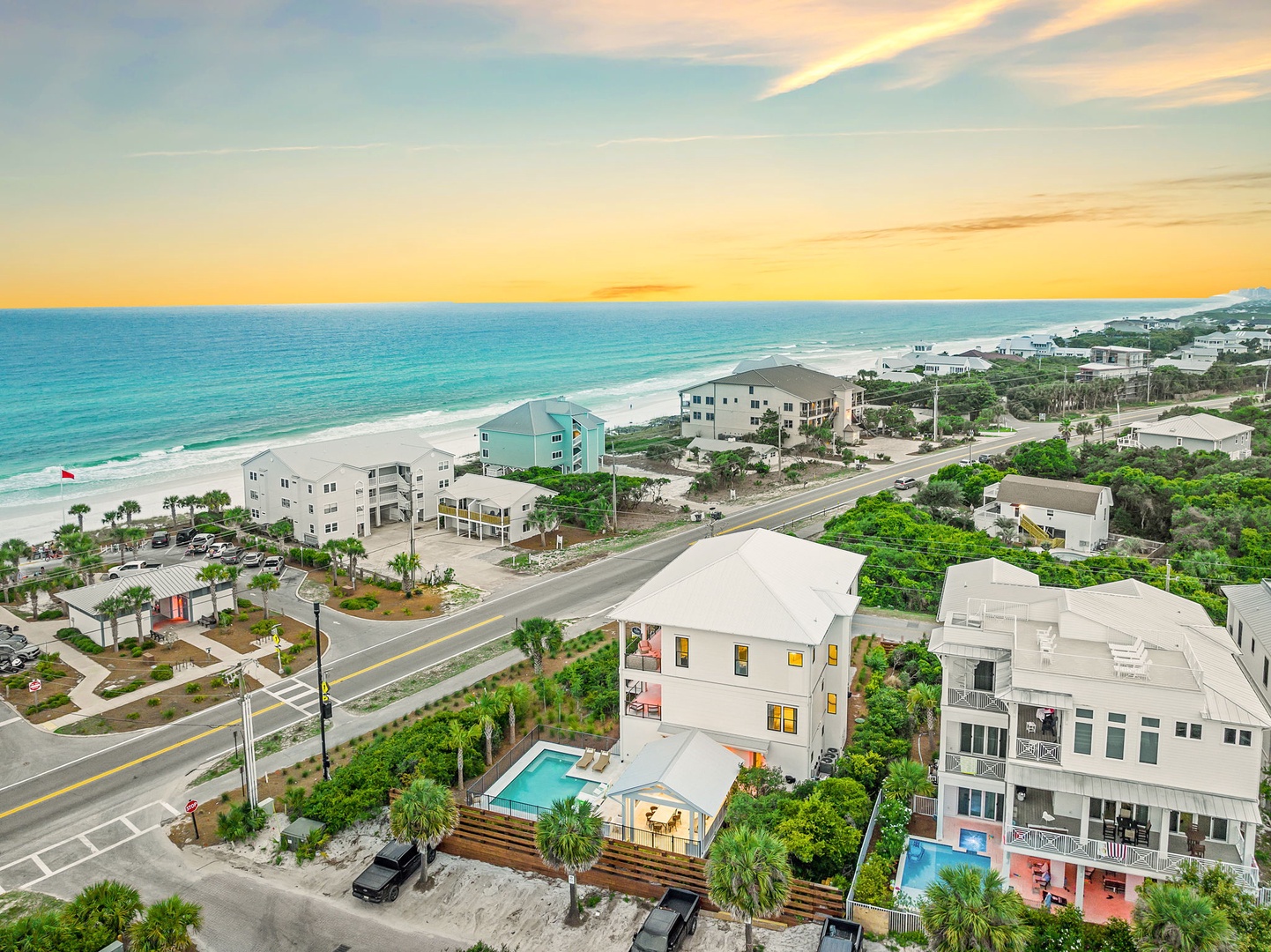 Aerial view of beachfront properties along Florida's Gulf Coast at sunset, showcasing the property's prime location steps from pristine white sand beaches.