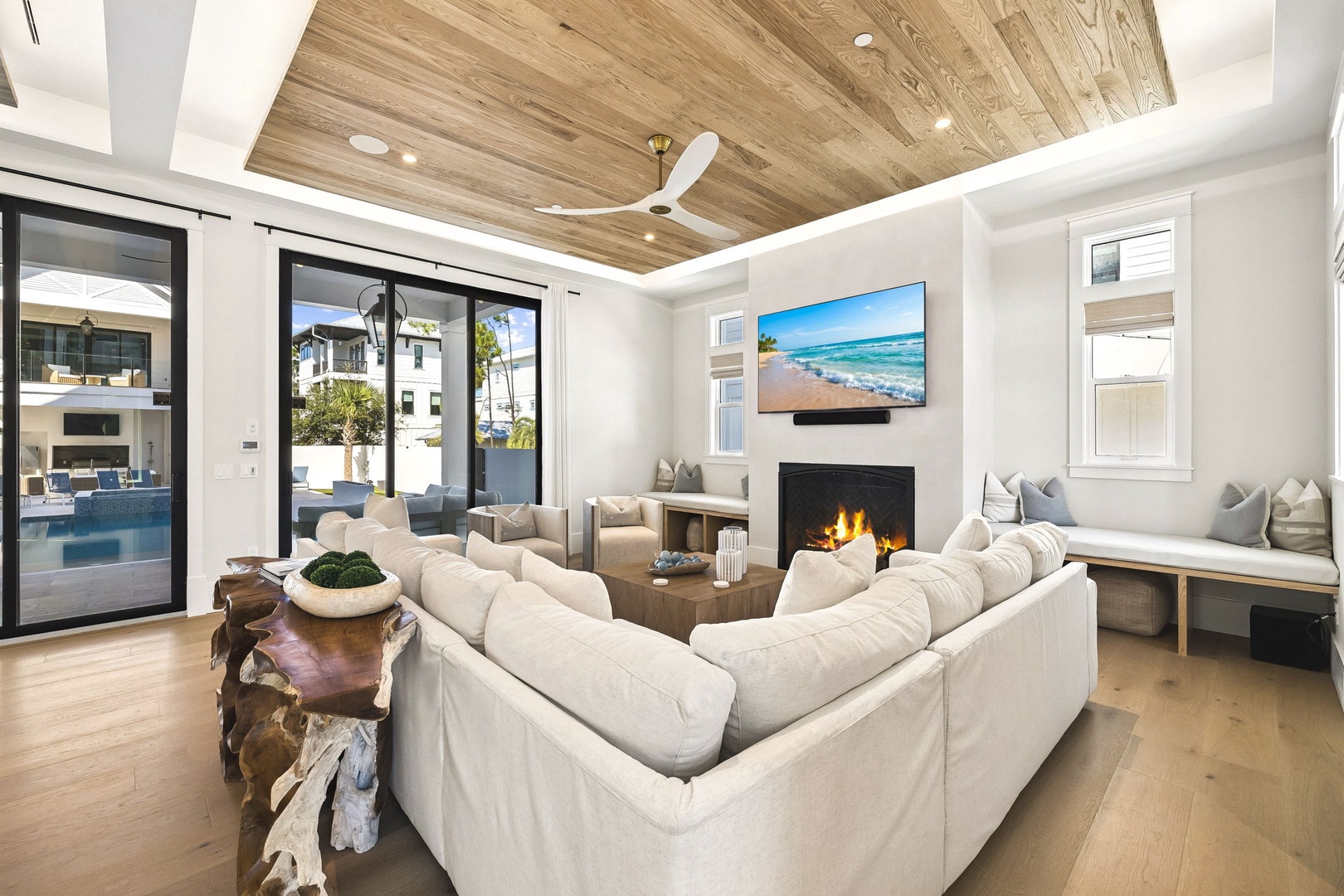 Sink into plush seating by the warm fireplace, where natural wood accents and abundant natural light create your perfect coastal retreat.