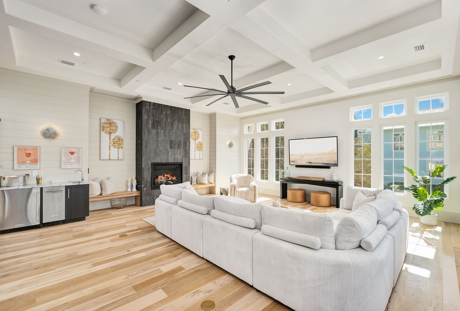 Sink into plush seating while your modern fireplace creates warmth and ambiance in this elegant living space with soaring coffered ceilings.
