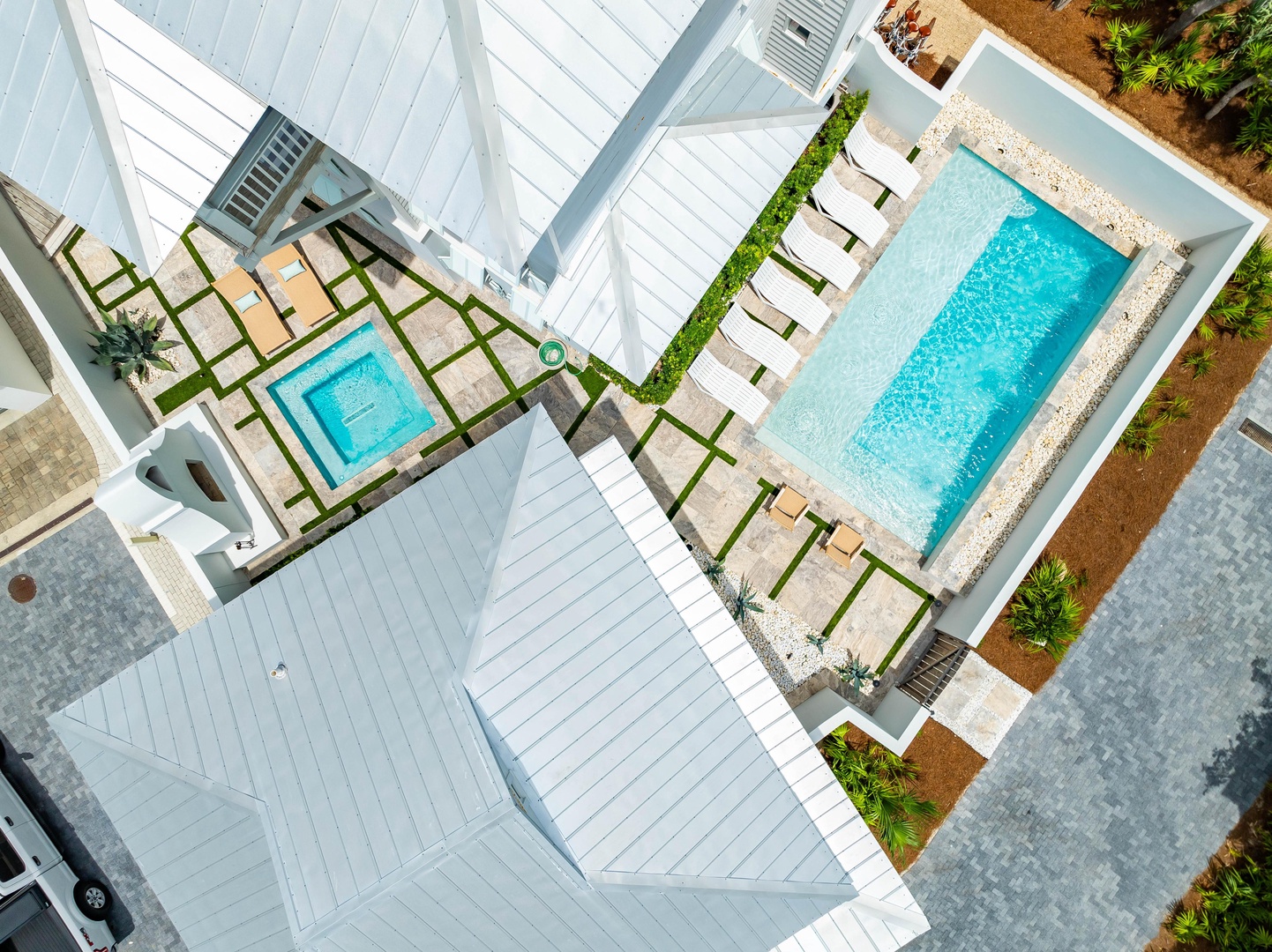 Modern resort property featuring twin swimming pools with pristine poolside lounging areas and contemporary white architecture.