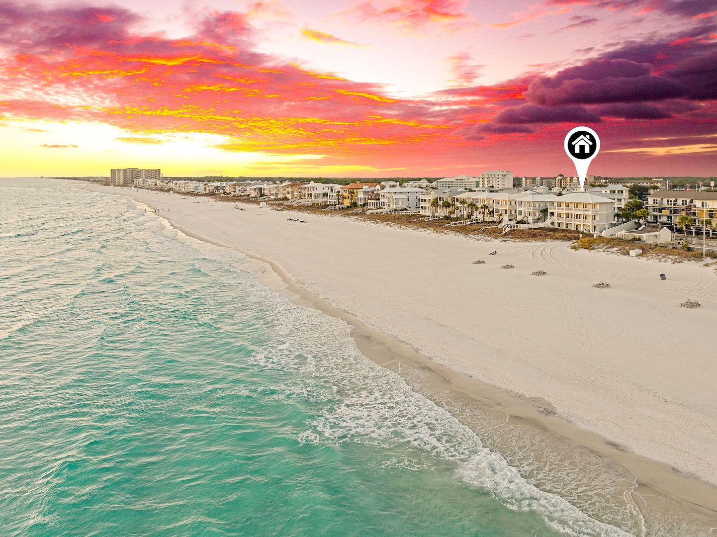 Spectacular sunset paints the sky in vibrant hues over a pristine beachfront location, showcasing the stunning coastal setting and surrounding neighborhood.