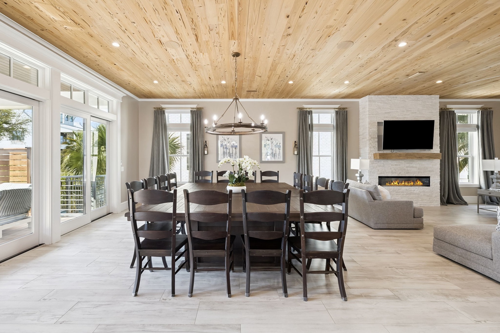 Gather around your grand dining table beneath soaring wood-beamed ceilings, where the cozy fireplace creates perfect ambiance for memorable meals.