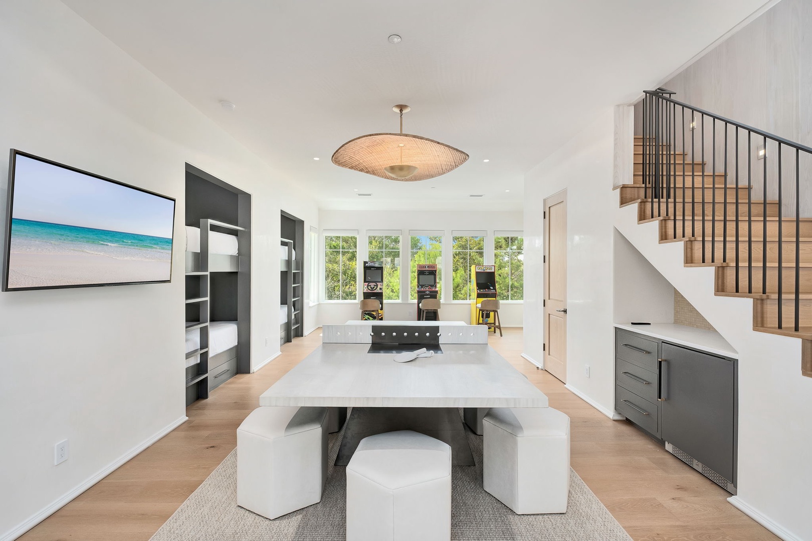 Gather around a sleek dining table in your open, light-filled living space where thoughtful design meets comfortable functionality. Natural light streams through expansive windows while modern finishes invite you to relax and reconnect.