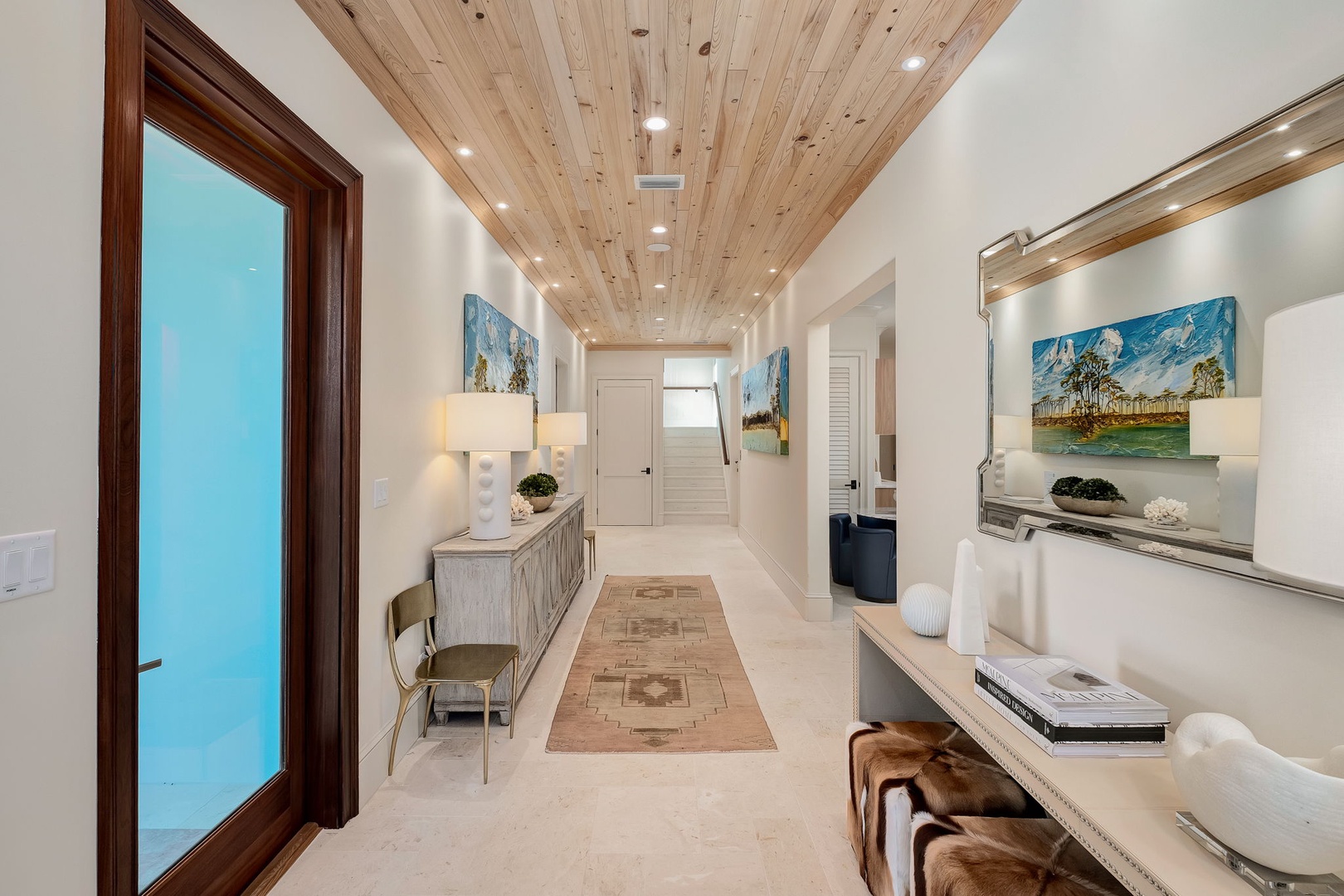 Step into this stunning hallway where natural wood ceilings and soft lighting create a warm, welcoming atmosphere. Thoughtfully designed with stylish decor and art, it sets a serene tone for your stay.