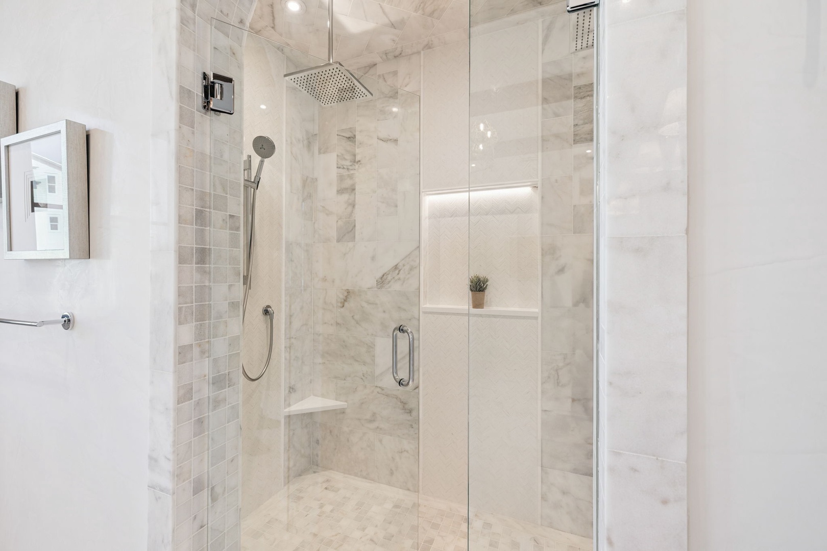 Step into your private spa-like shower with elegant marble finishes, dual rain and handheld showerheads, and a built-in bench for ultimate relaxation.