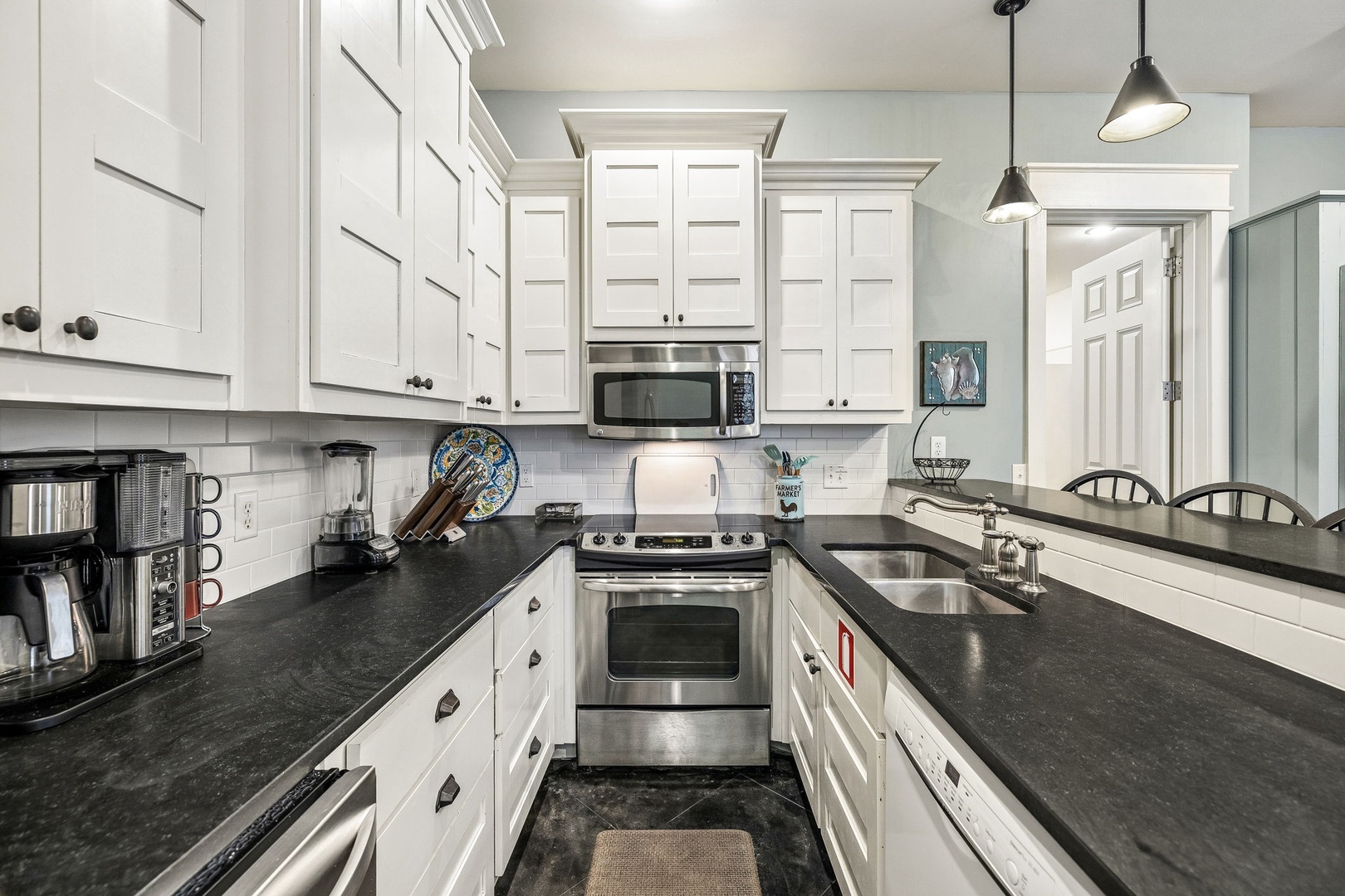 Your home-away-from-home kitchen invites you to cook with style—crisp white cabinetry, sleek dark countertops, and modern appliances ready to help you create delicious meals together.