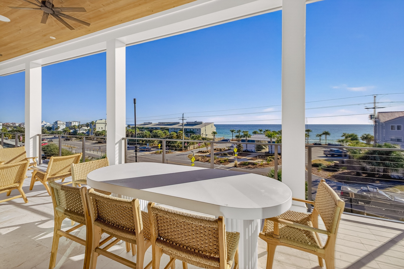 Sip your morning coffee at this stunning coastal balcony, where panoramic ocean views stretch endlessly beyond wicker seating.