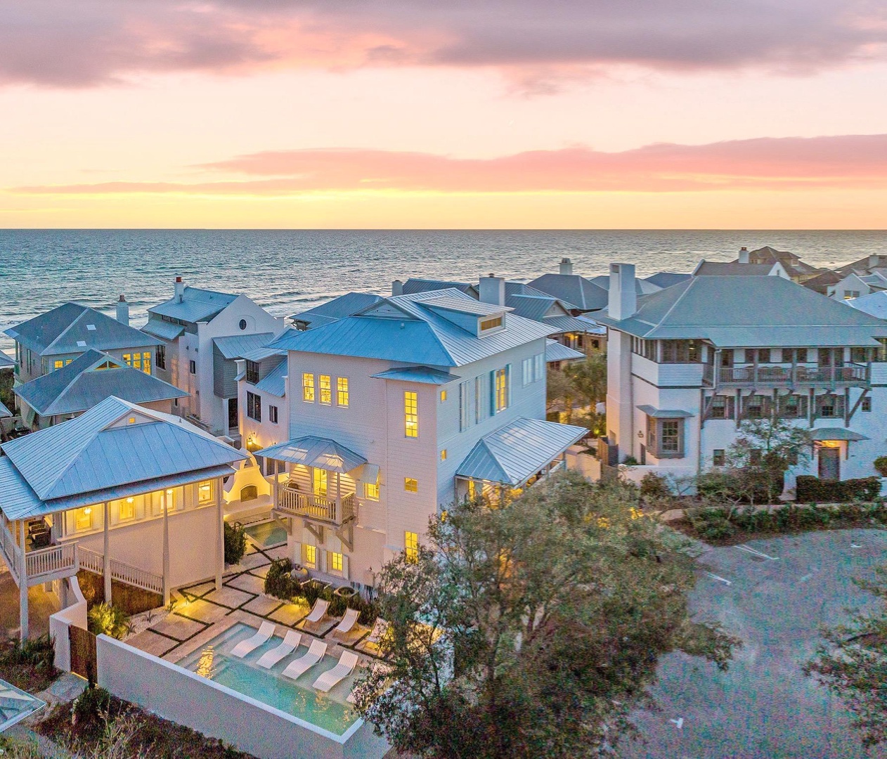 A stunning beachfront community with modern architecture illuminated during golden hour.