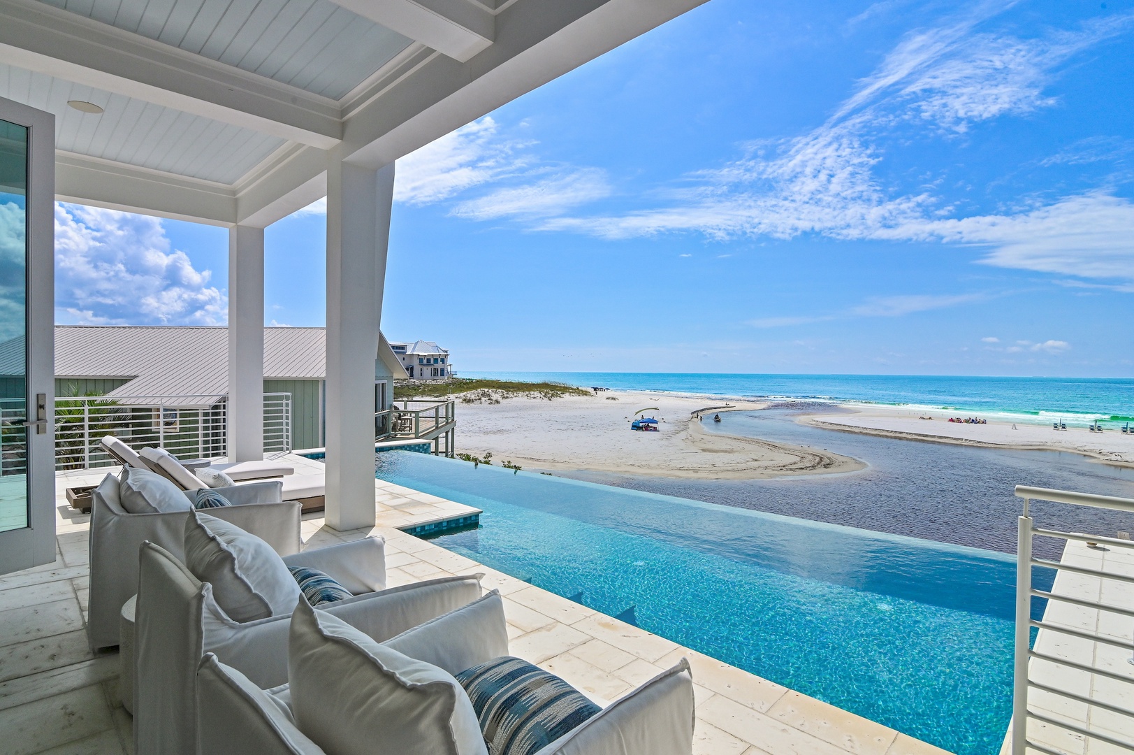 The infinity pool at this stunning beachfront property features direct access to pristine white sand and turquoise waters, creating a seamless connection between luxury and natural beauty.