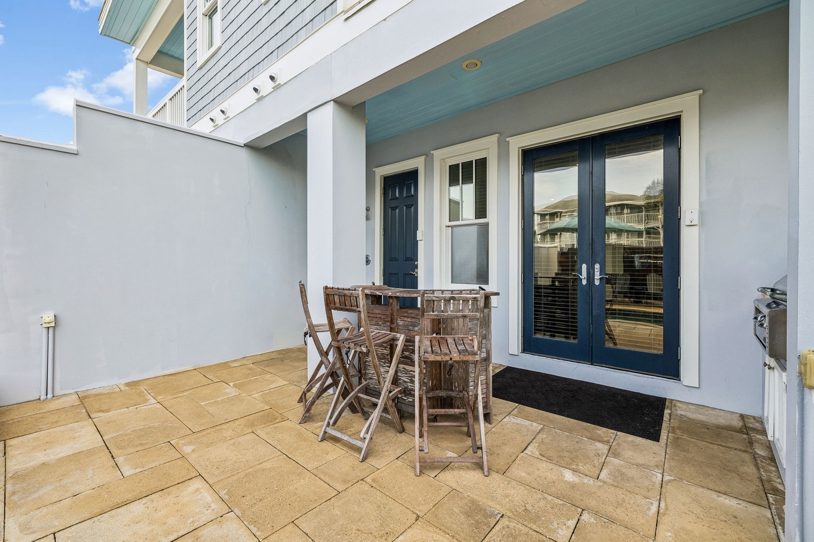 Your private patio features a charming bistro set where you can enjoy morning coffee or evening conversation under open skies, with easy access through elegant glass doors.