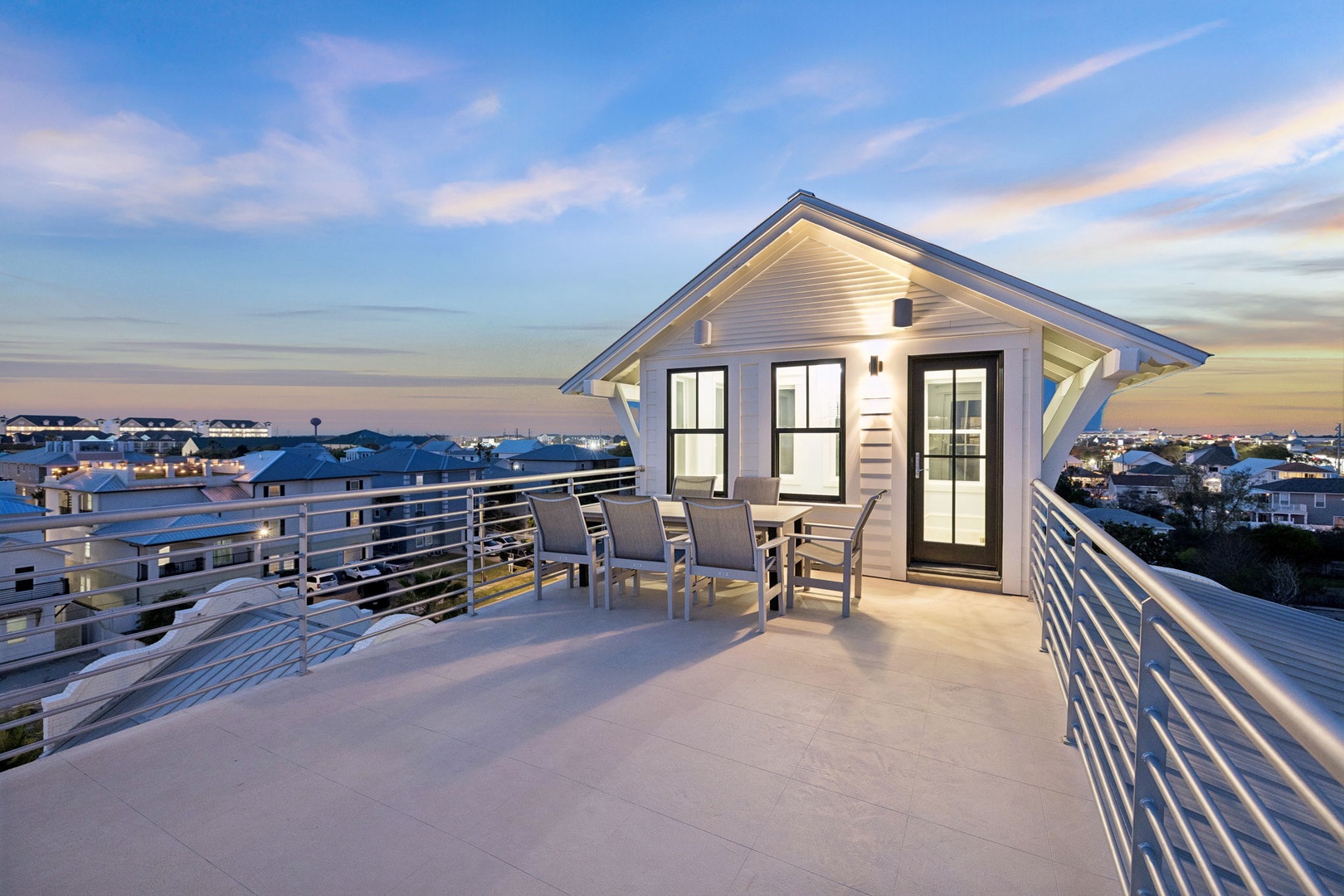 Rooftop terrace with panoramic neighborhood views and outdoor dining space for evening relaxation.
