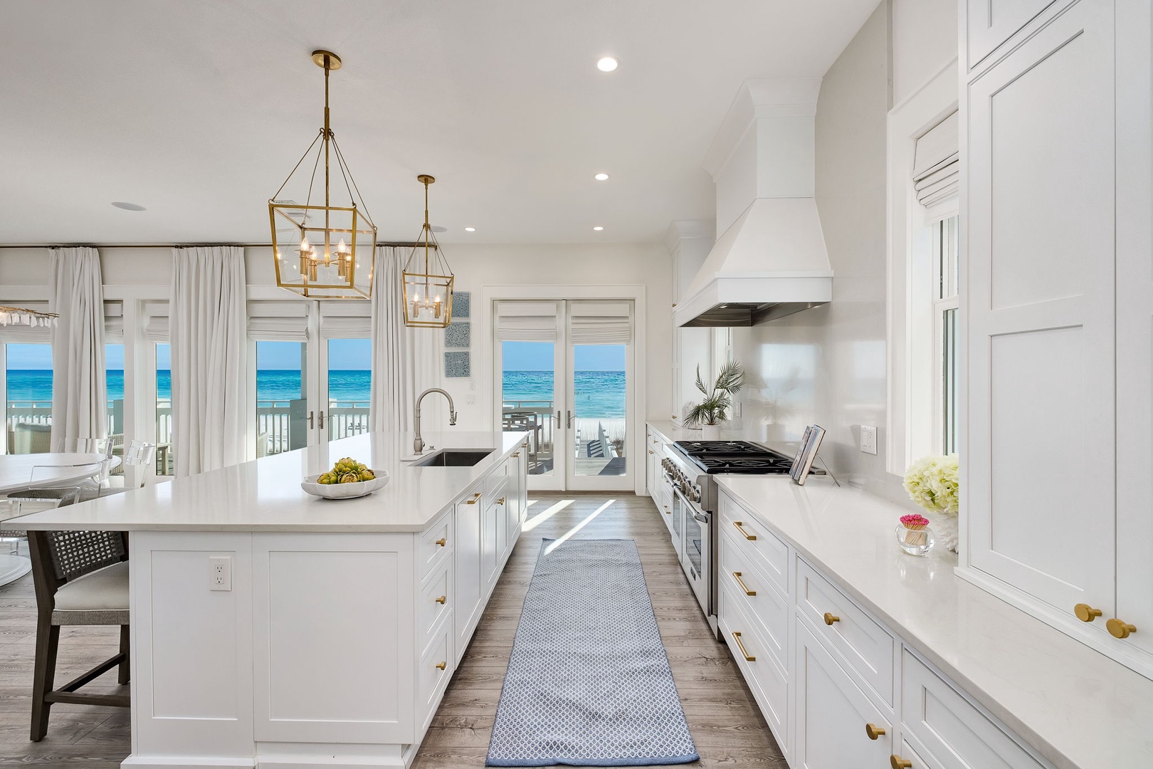 Imagine preparing your favorite meal in this airy, sun-drenched kitchen, where every glance toward the windows reveals stunning ocean waves just beyond your balcony.