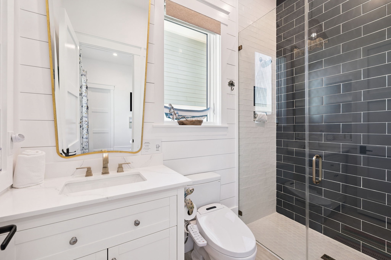 Step into your spa-like bathroom with elegant gold fixtures, gleaming subway tile shower, and crisp white finishes that create a luxurious retreat.