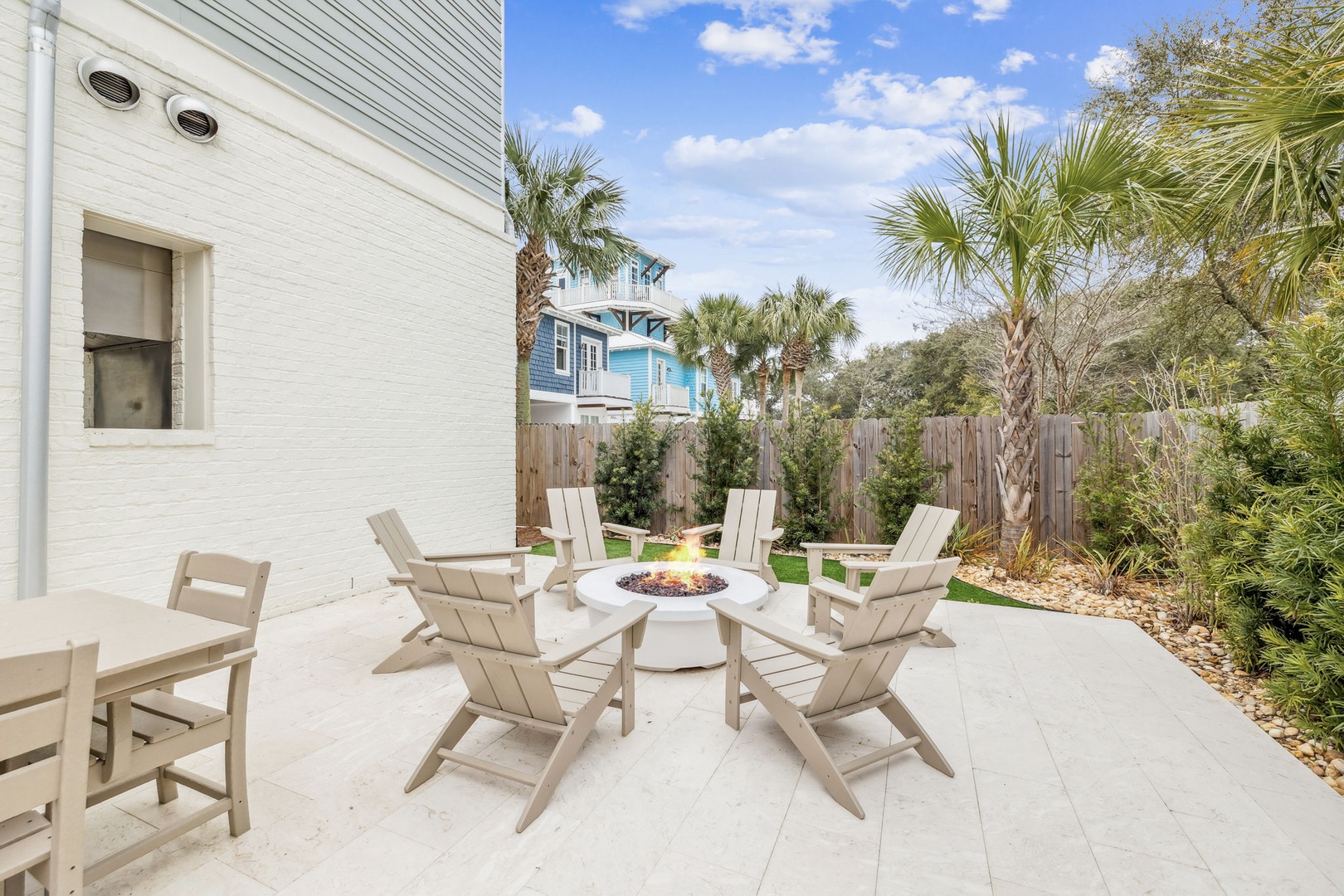 Gather around your private fire pit for memorable evenings under the palms in this peaceful backyard oasis.