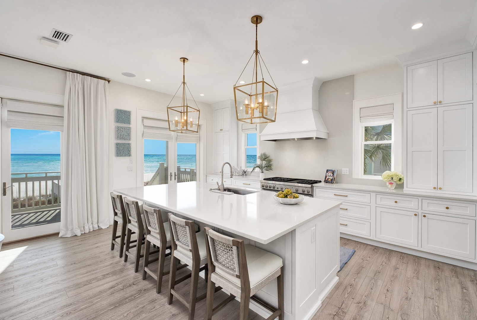 This bright, coastal kitchen opens onto a private deck overlooking the ocean. Picture yourself preparing meals at the spacious island while enjoying stunning sea views through large windows that fill the room with natural light.