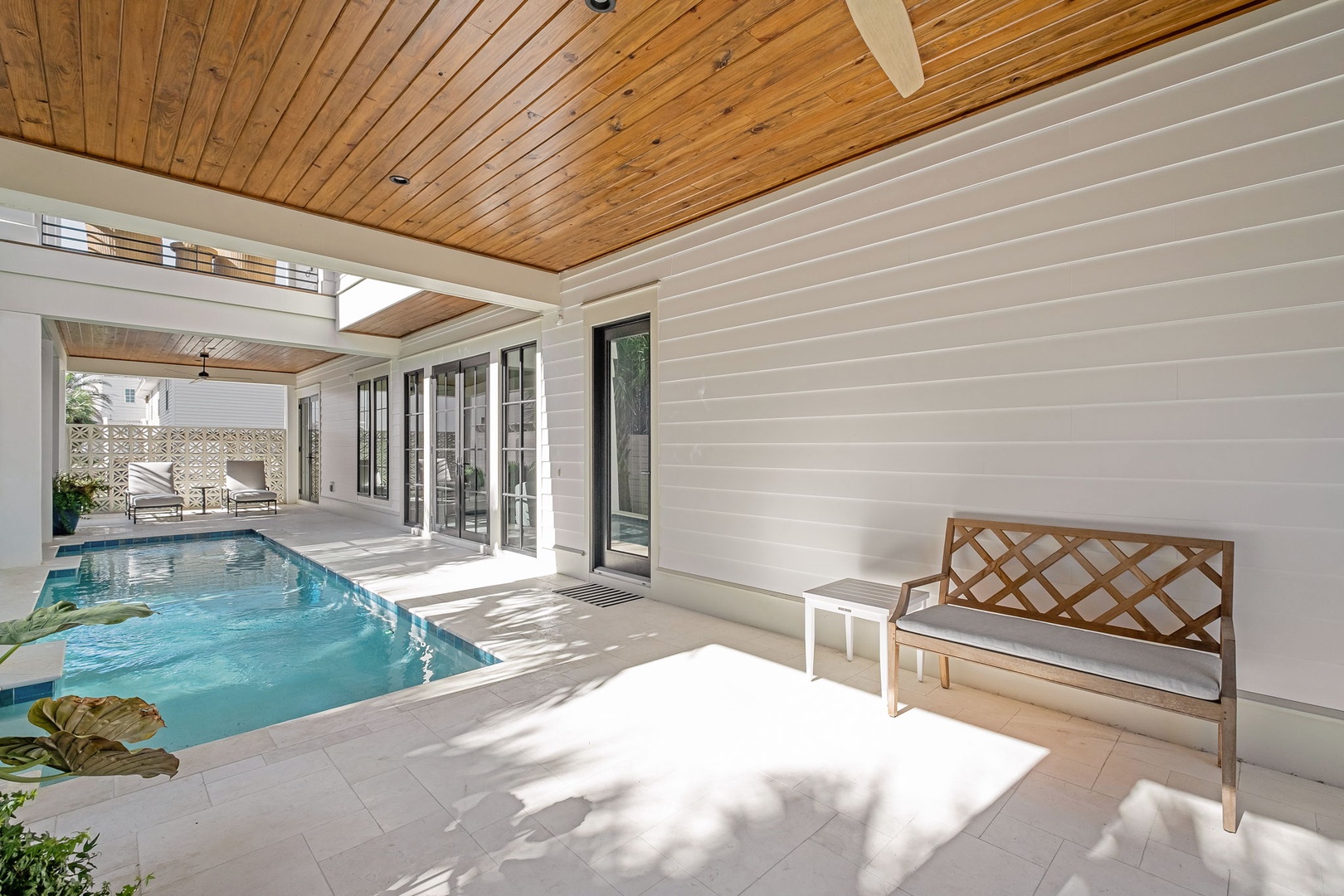 Step into your private oasis where warm wood ceilings frame a sparkling pool just steps from your door.