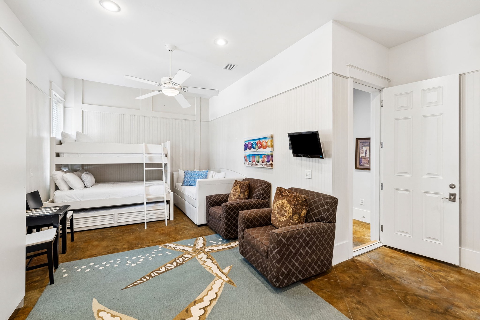 Bright coastal studio featuring bunk beds, a cozy sofa, and thoughtful beach-themed touches. Your retreat stays comfortable year-round with ceiling fan and welcoming natural light.