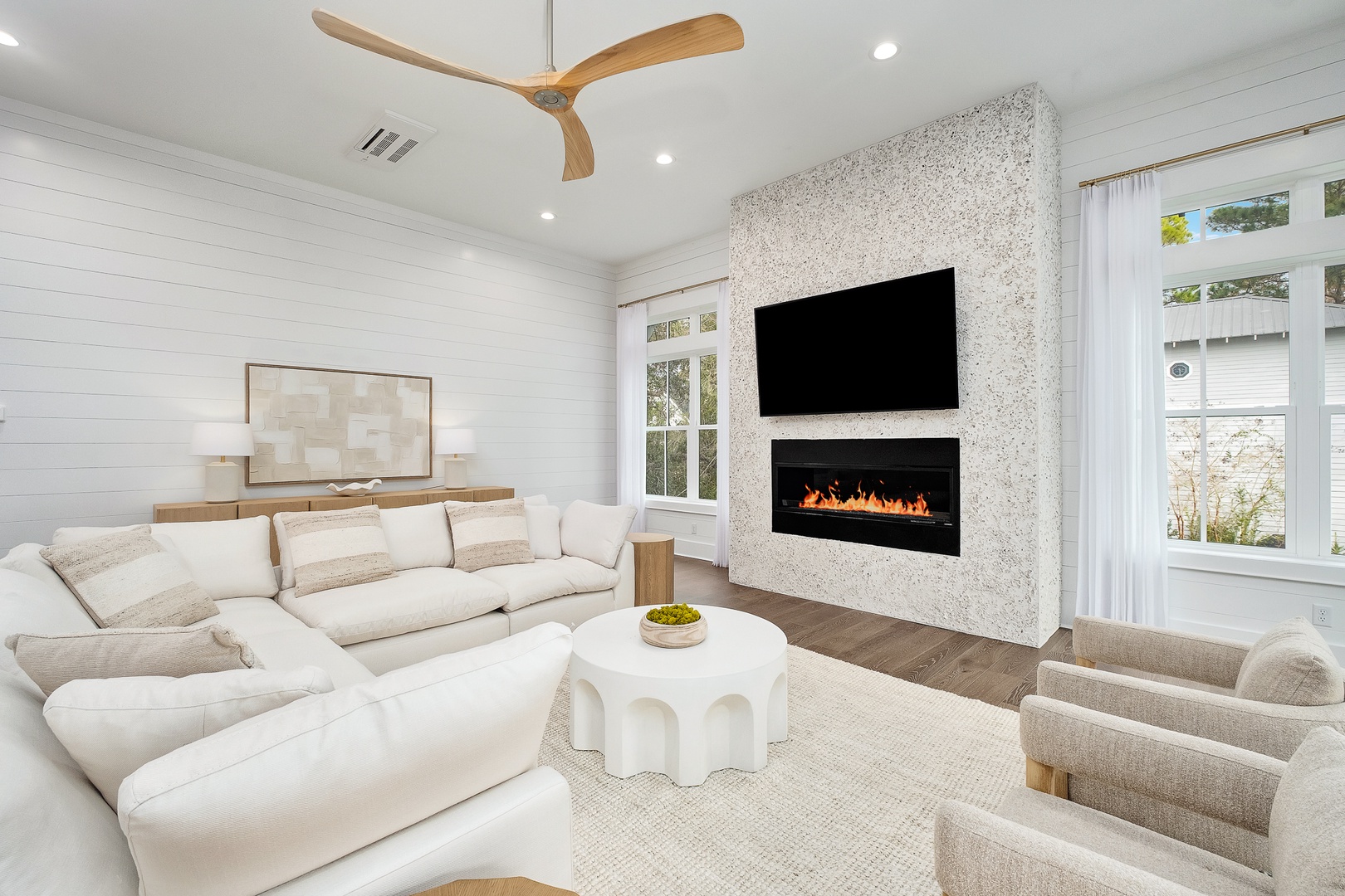 Sink into plush seating while the fireplace crackles warmly beneath your favorite shows on the wall-mounted TV.