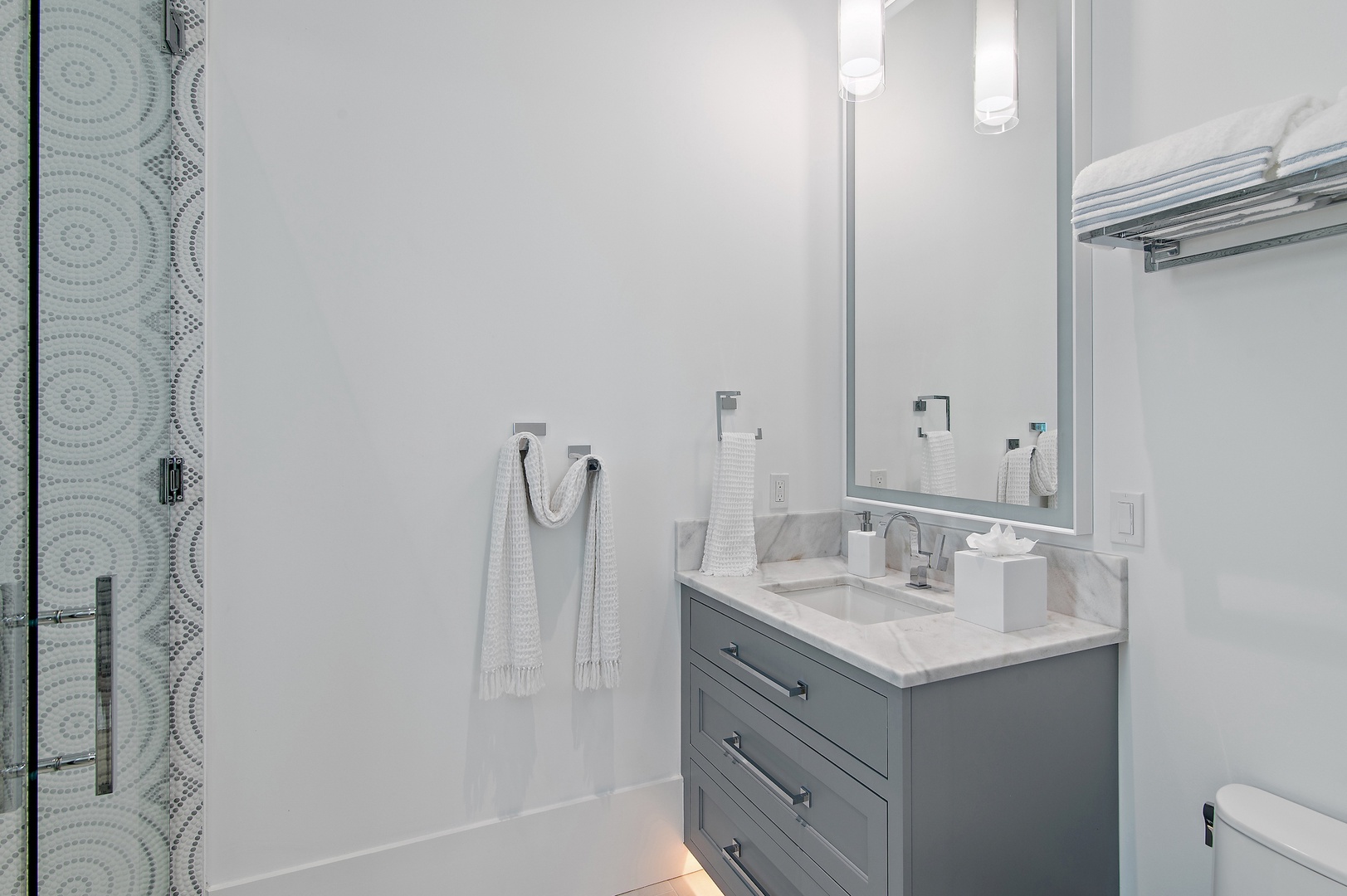 Step into your spa-like bathroom with elegant marble countertops, soft lighting, and plush towels waiting for you after a refreshing shower.