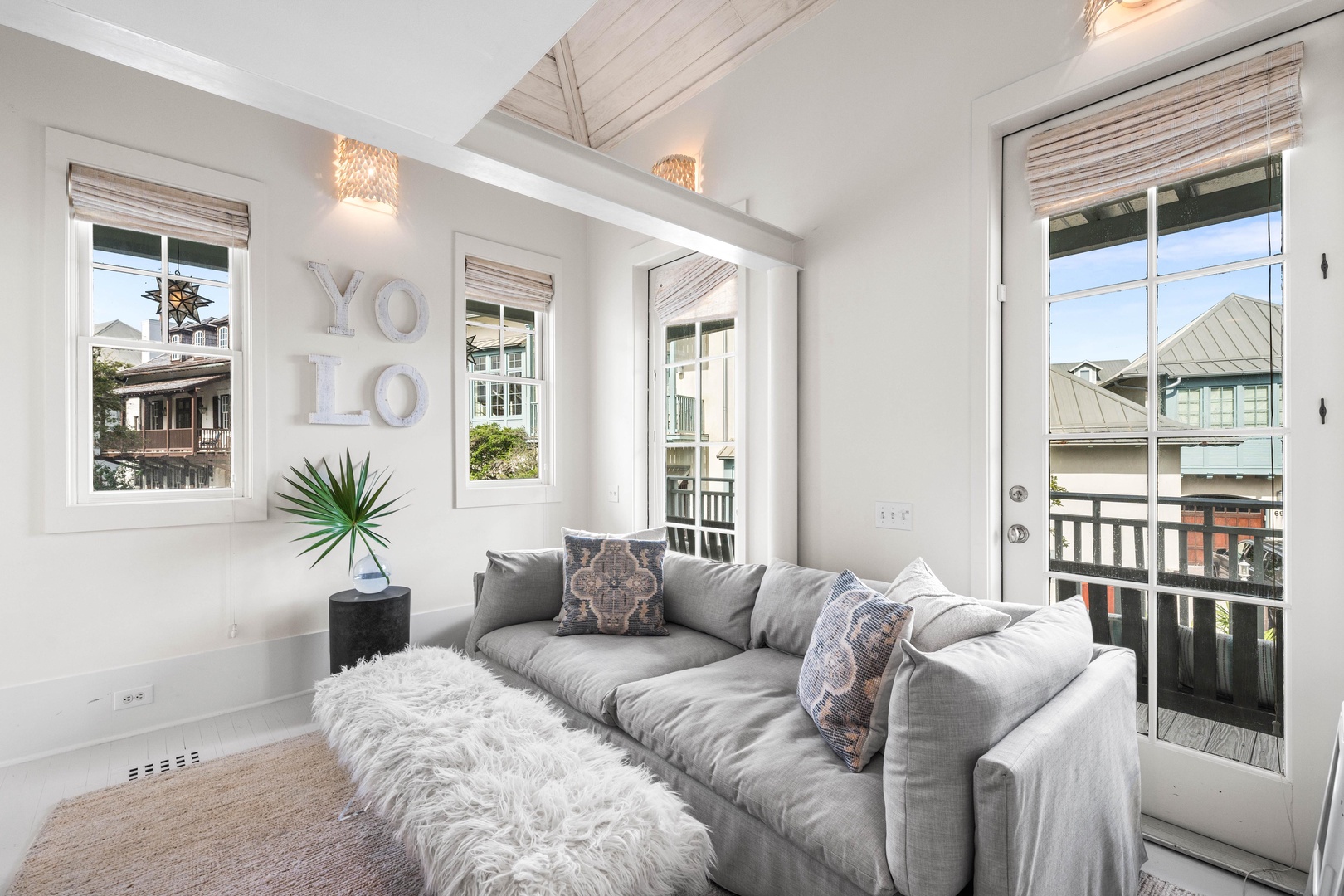 Sink into plush gray seating while natural light streams through multiple windows, creating your perfect sanctuary for morning coffee or evening relaxation.