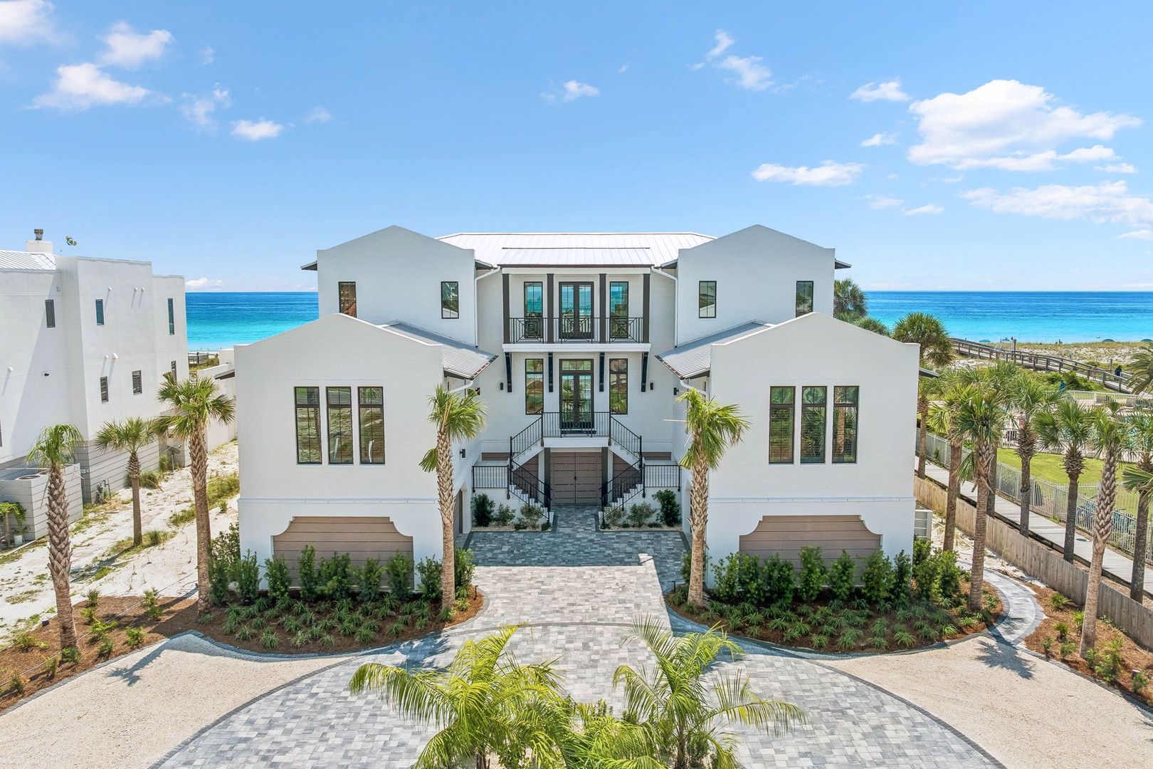 This stunning beachfront property features elegant architecture with pristine white exteriors, lush tropical landscaping, and direct access to turquoise waters and pristine sandy shores.