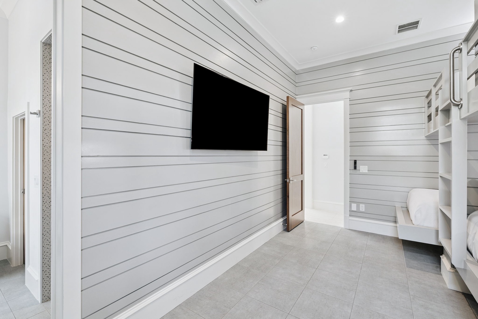 You'll love the sleek white shiplap walls and flat-screen TV in this modern space with built-in bunks for extra guests.