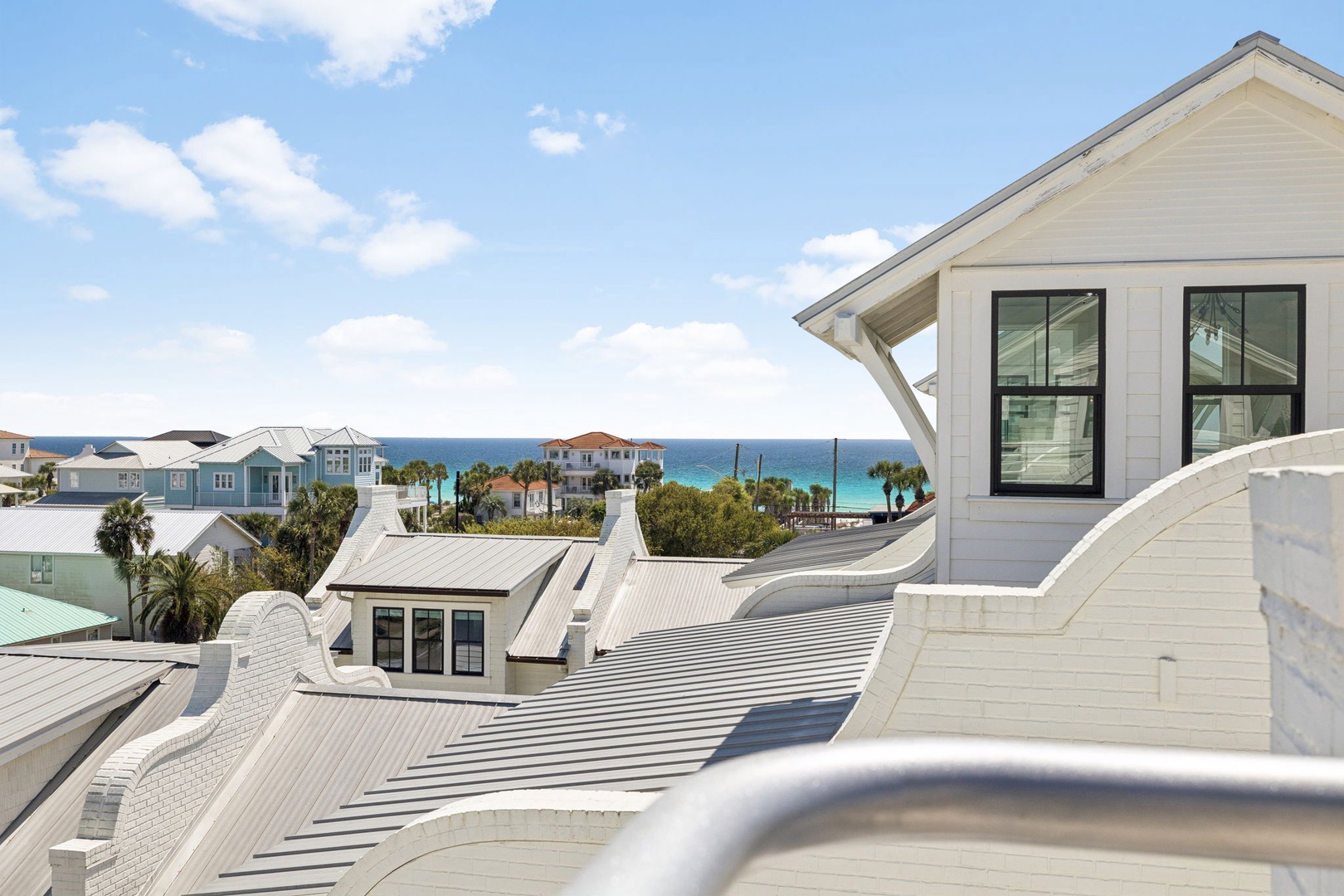 Elevated coastal property featuring stunning sea views over rooftops with turquoise waters visible in the distance.