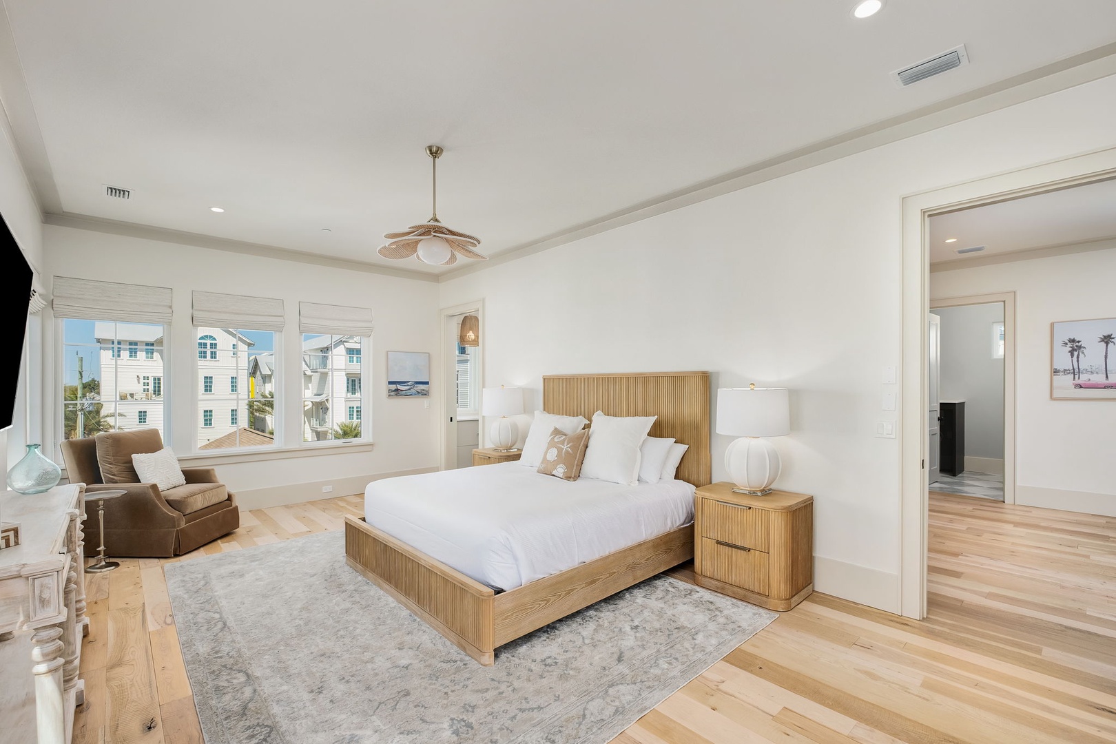 Drift off in your serene bedroom with warm wood tones, crisp linens, and ocean breezes through large windows.