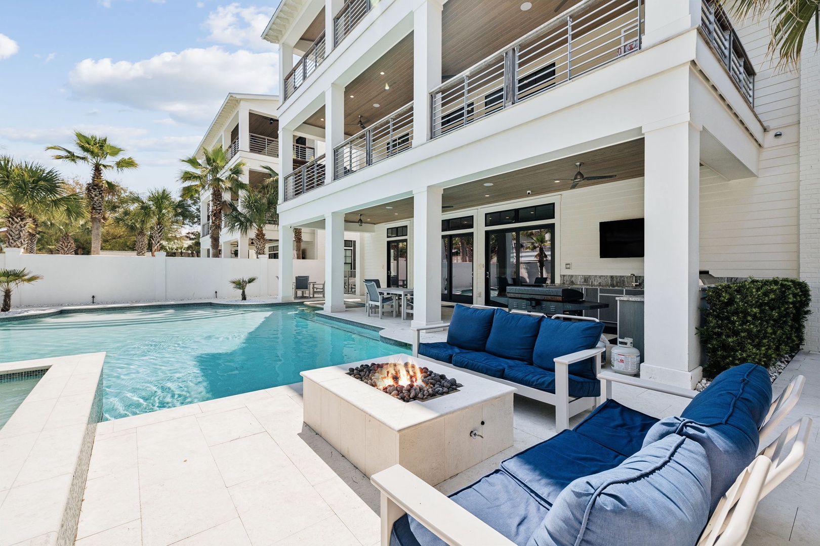 Unwind by your private pool with a crackling fire pit as centerpiece, surrounded by plush seating perfect for evening conversations under the stars.