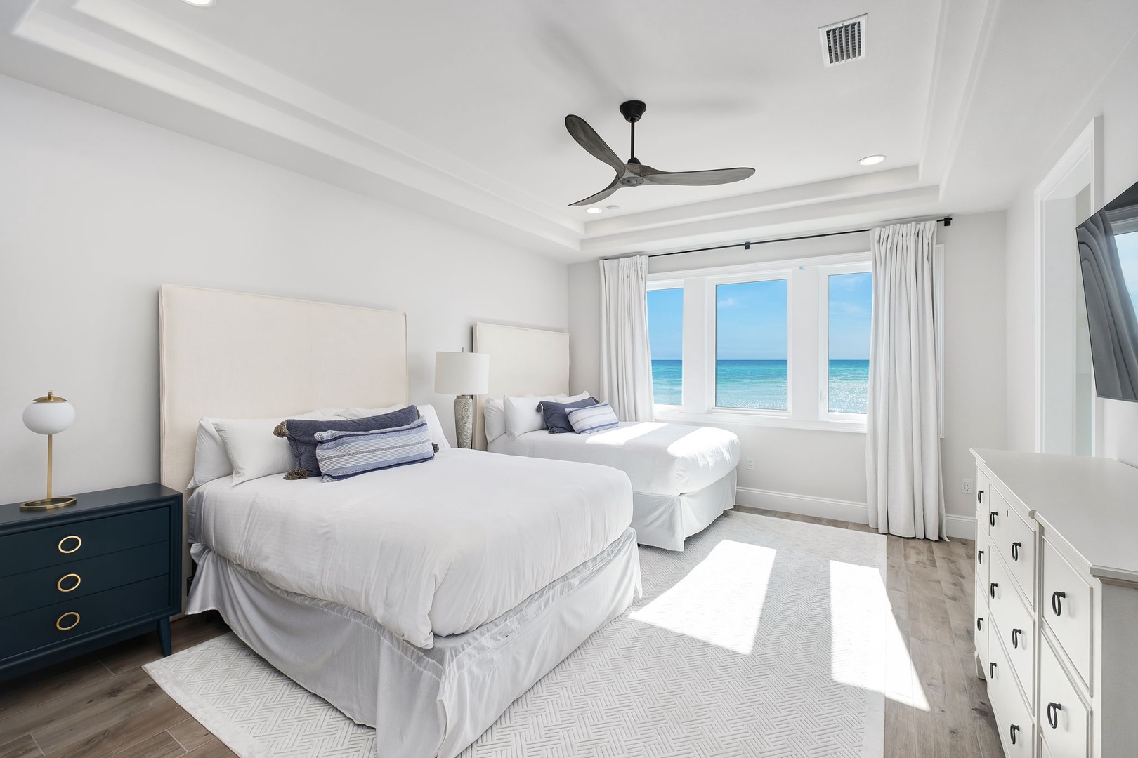 Wake up to stunning ocean views in this serene bedroom, where crisp white linens and coastal breezes create your perfect seaside retreat.