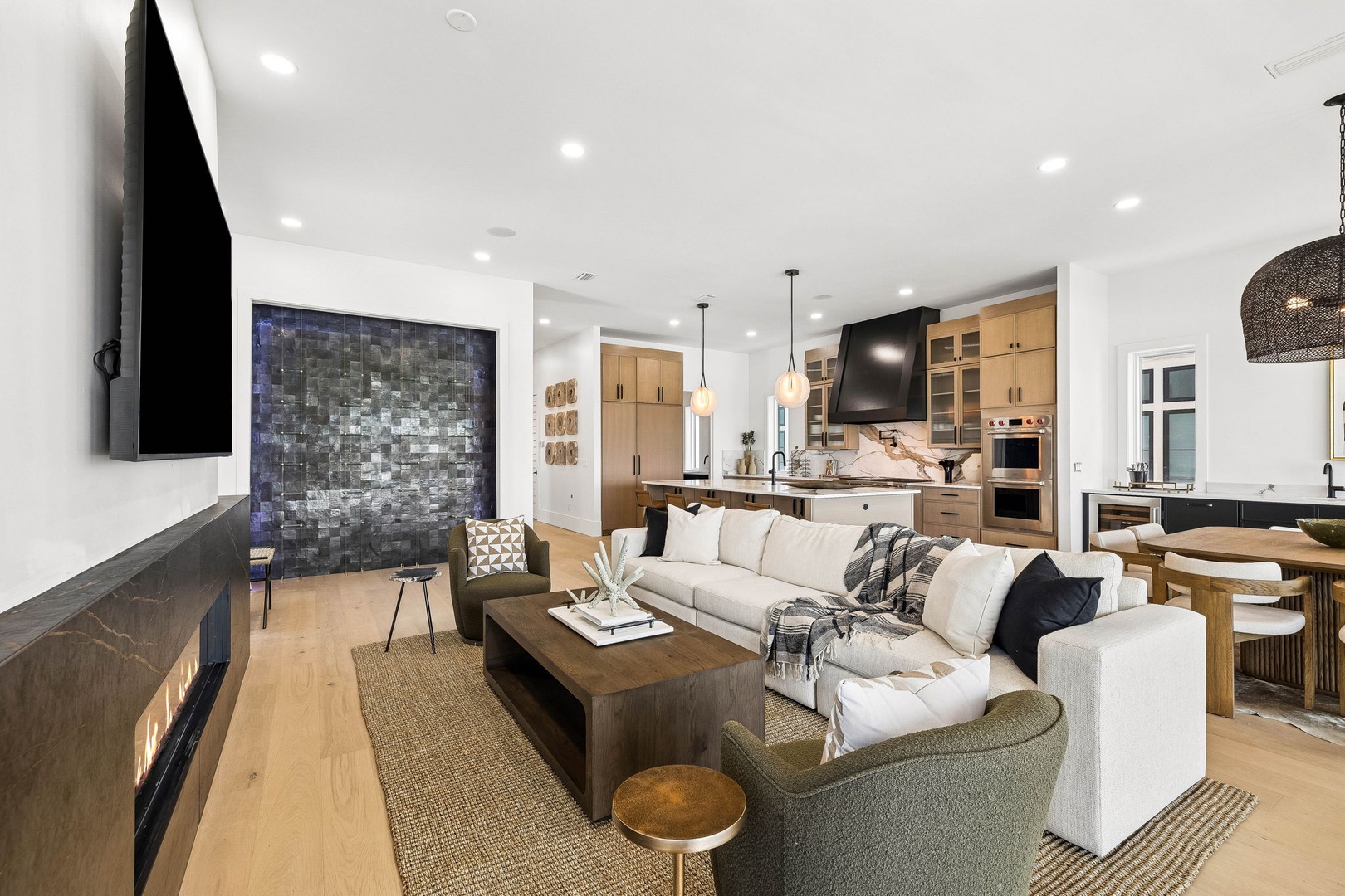 Settle into your spacious living area where natural textures and clean lines create a serene retreat. Sink into plush seating surrounded by warm wood tones and designer lighting that invites you to unwind after a day of exploring.