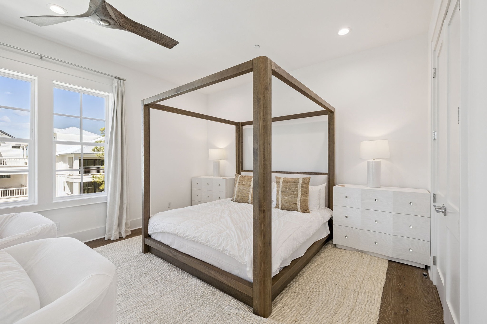 Your elegant canopy bed creates a serene coastal retreat, with crisp linens and warm wood tones for ultimate relaxation.