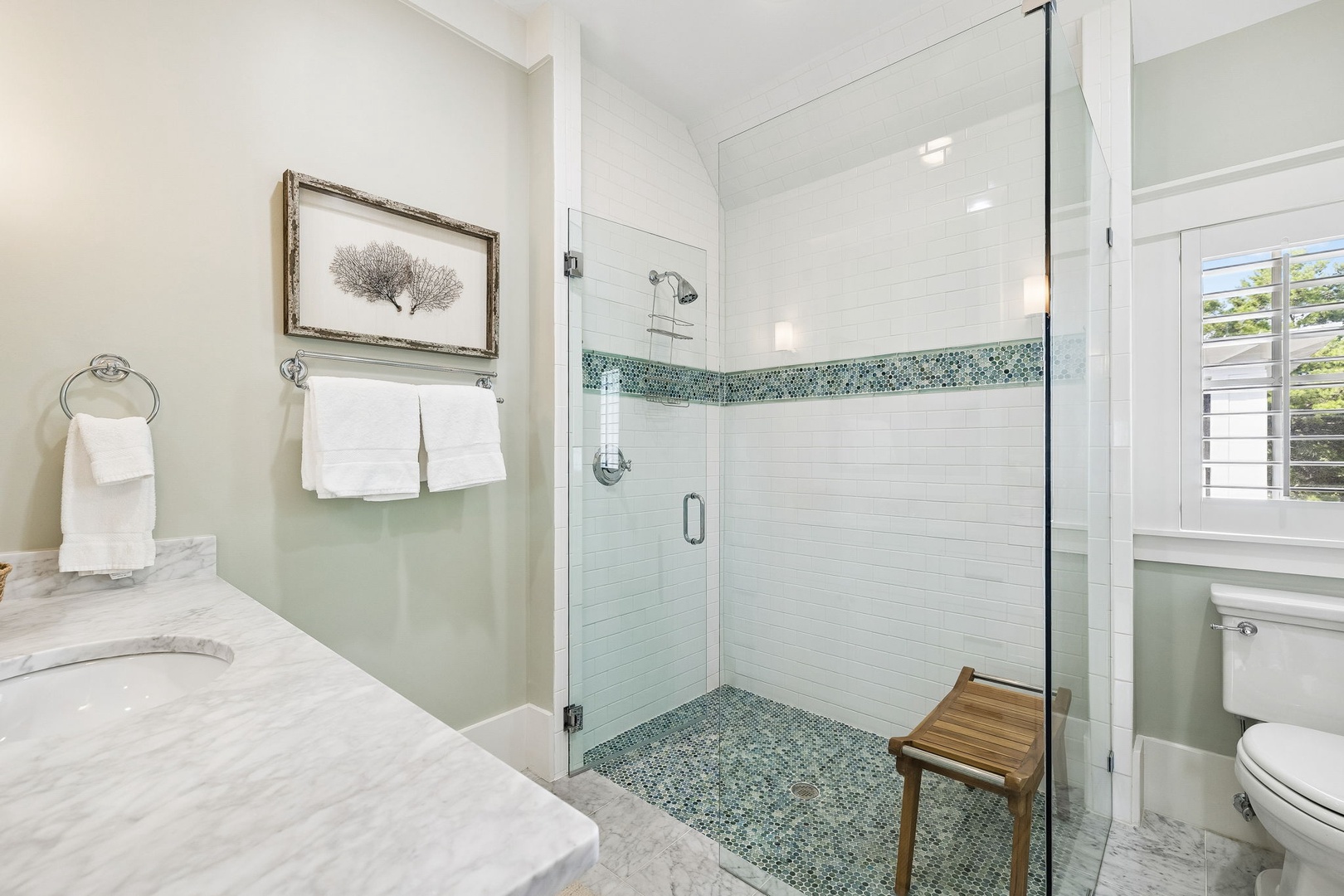 This serene bathroom awaits you with a beautifully tiled walk-in shower, soft towels, and elegant finishes—perfect for unwinding after your day.
