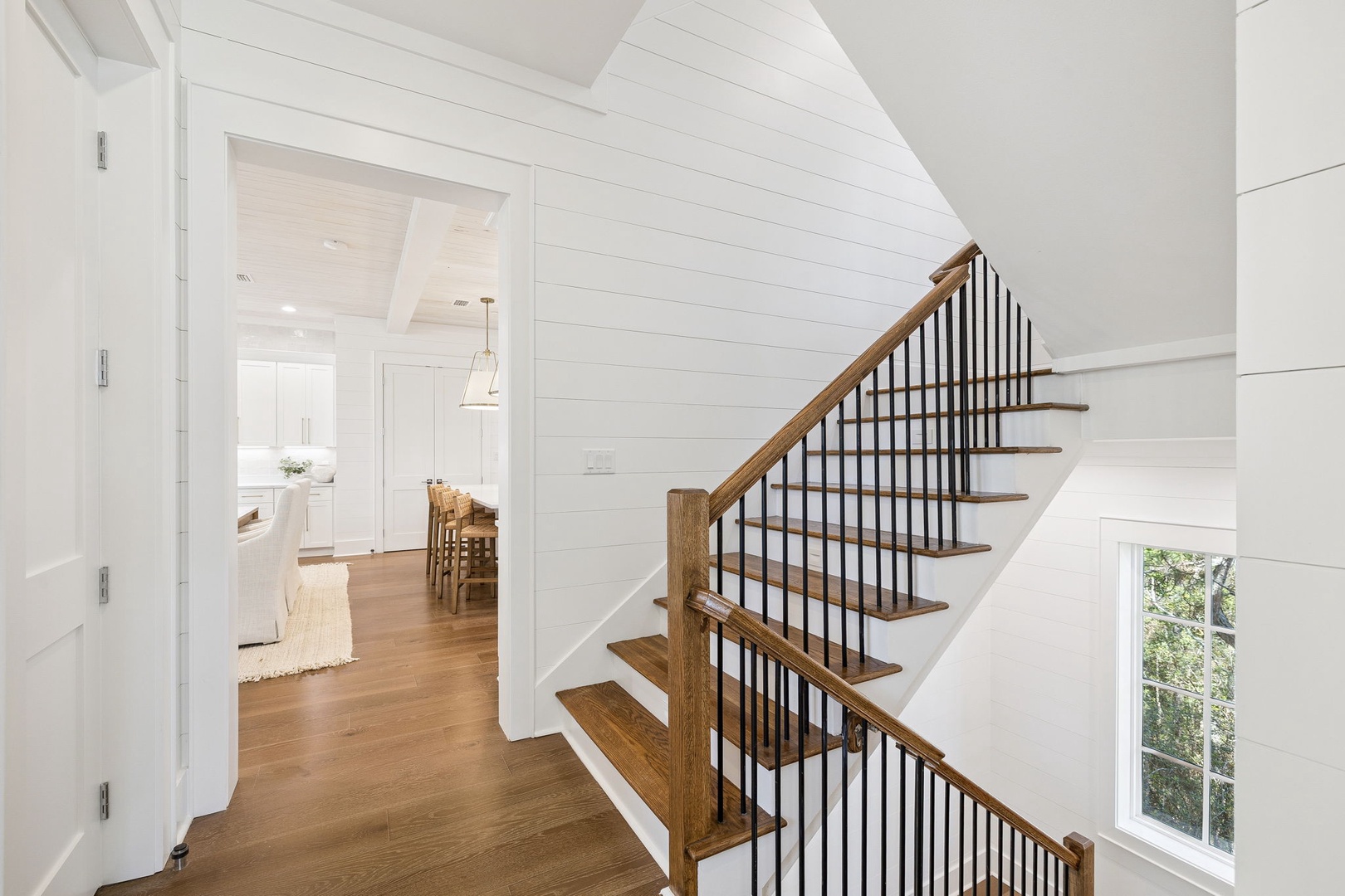Step into this bright farmhouse-style foyer where warm wood floors and shiplap walls create your welcoming first impression.