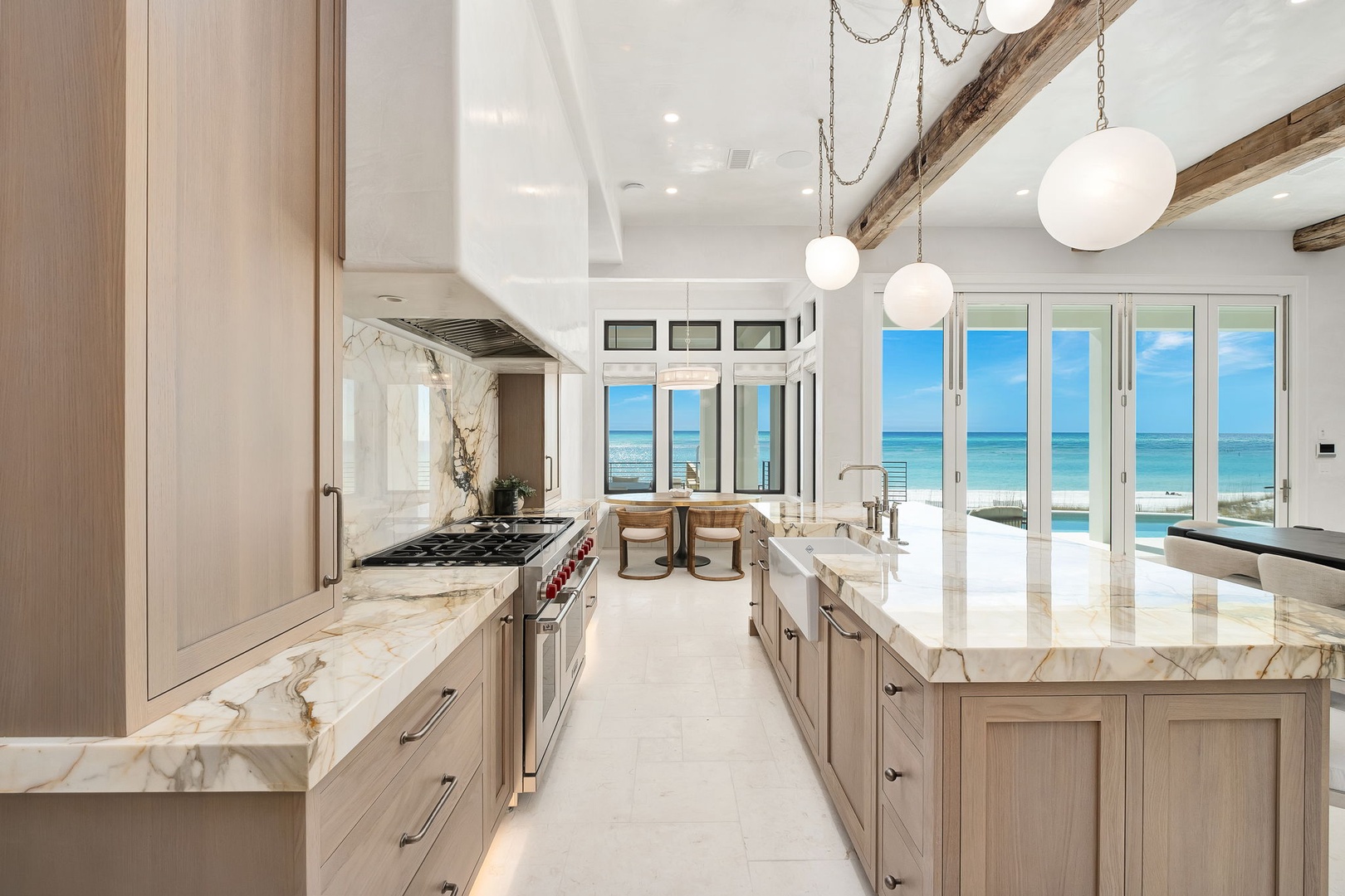 Your dream kitchen awaits with marble countertops and ocean views through floor-to-ceiling windows, perfect for morning coffee.