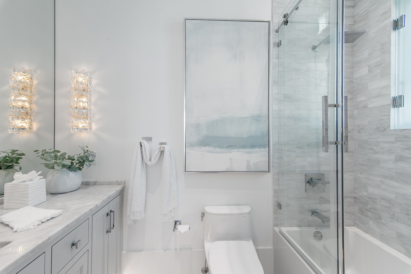 Step into your beautifully appointed bathroom, where coastal-inspired tile and elegant lighting create a serene, spa-like retreat. The marble vanity and glass-enclosed tub make unwinding after a day of adventure feel effortless.