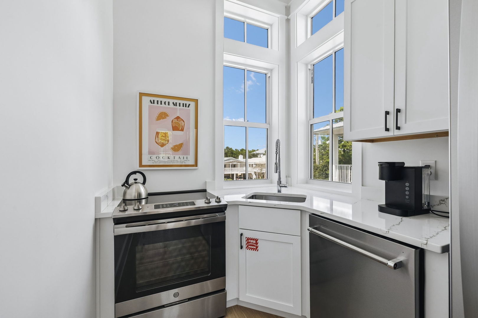 This bright corner kitchen is fully equipped for your morning coffee ritual and easy meal prep. Natural light pours through tall windows, and modern appliances are ready when you are.